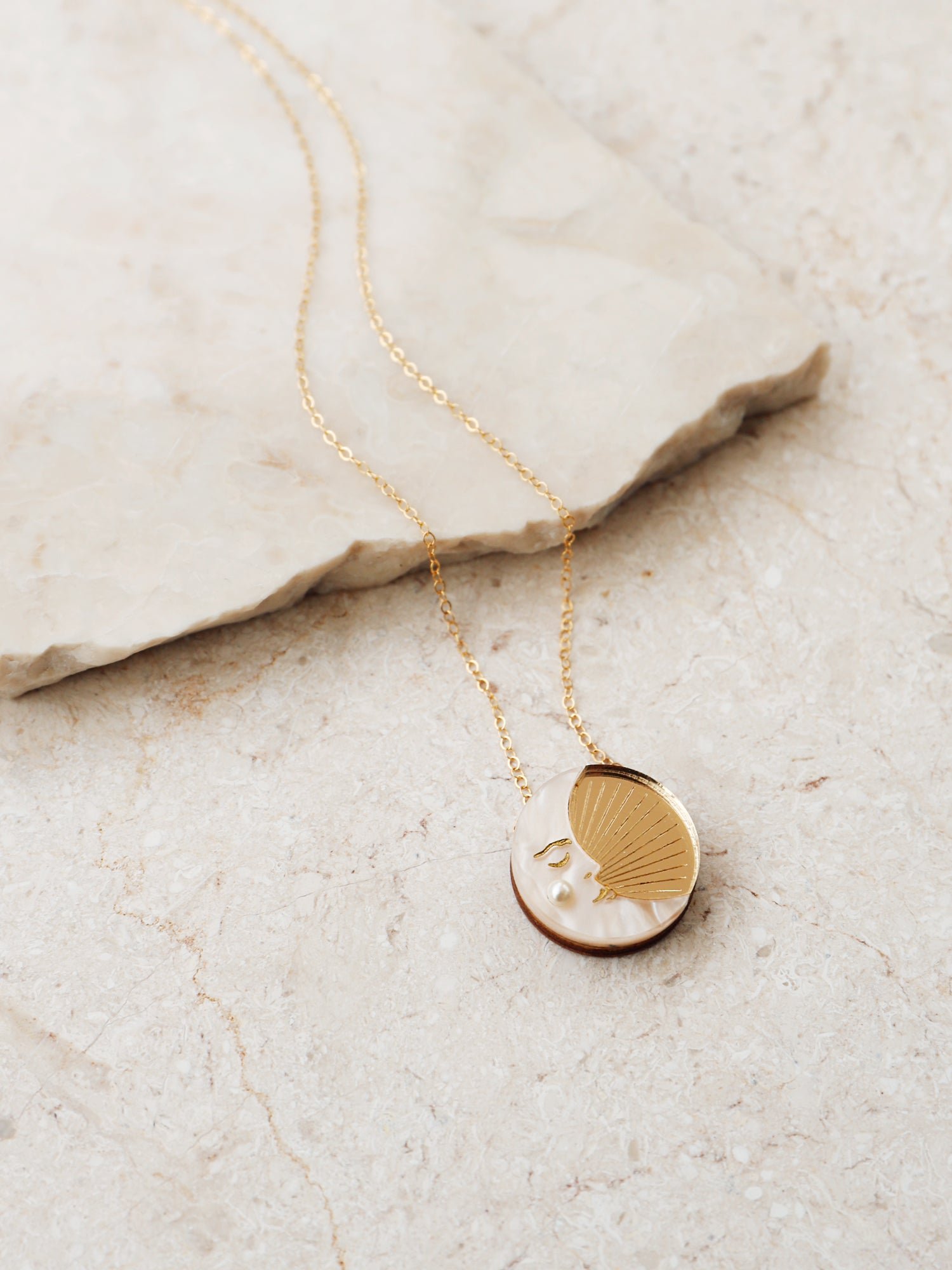 Wolf & Moon 金色月亮項鍊，配有金鏡面壓克力與奶油大理石紋壓克力製成的月牙吊墜，掛於金填充鍊條上。.