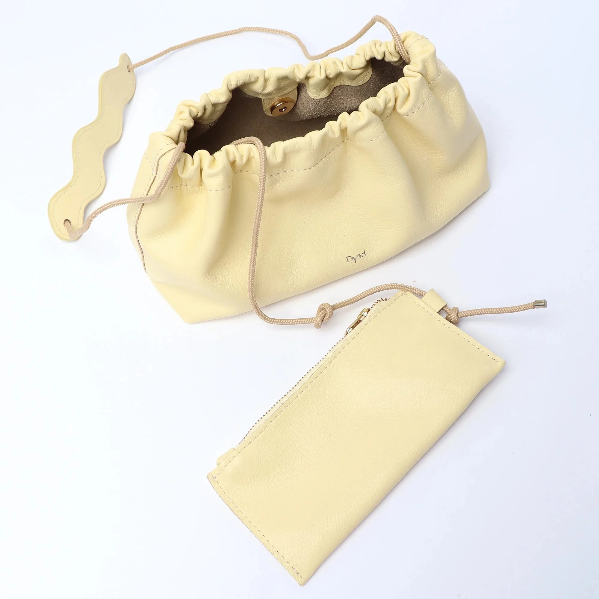 Wave Bag in butter yellow canvas with pleated silhouette and adjustable strap, handmade by Project Dyad in Cape Town.