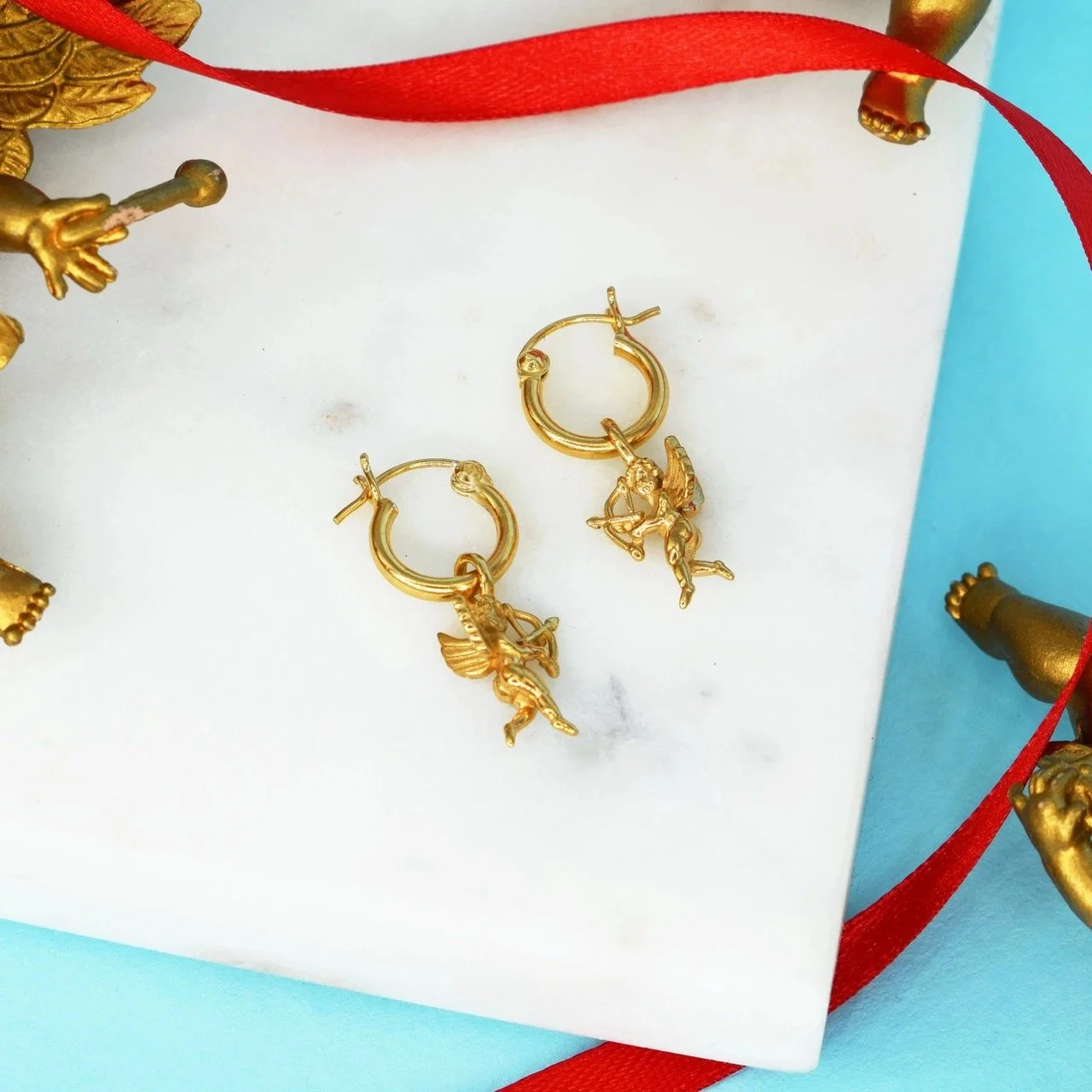 Good Daze Flying Cupid Hoop Earrings with 12mm hoops and 14mm 3D Cupid charm, available in sterling silver or 18k gold vermeil, ethically made in East London and gift wrapped with Goosebump ring box.