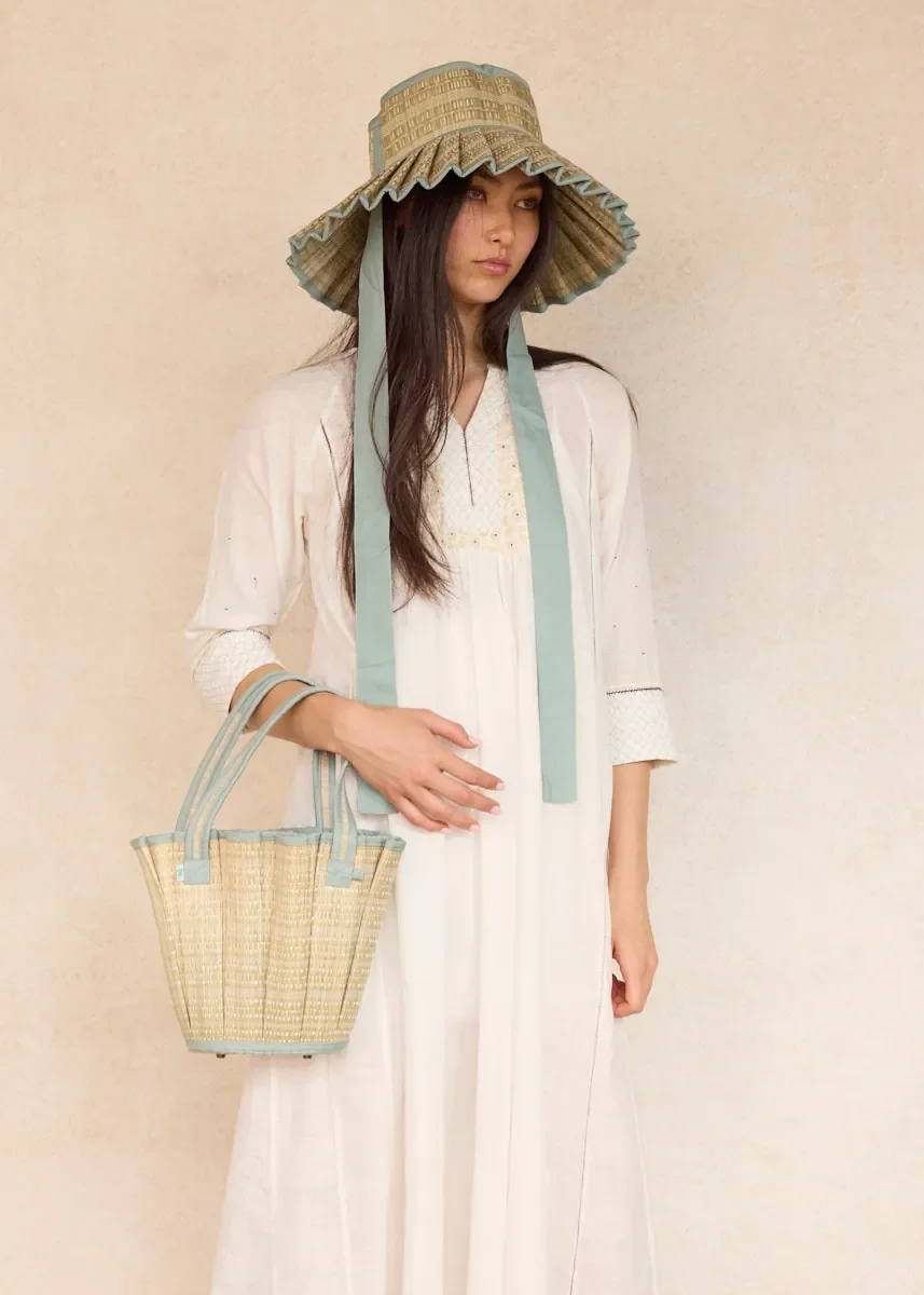 Model carrying the Lorna Murray Polynesia Mini Tropez Tote, showcasing its compact handcrafted woven design.