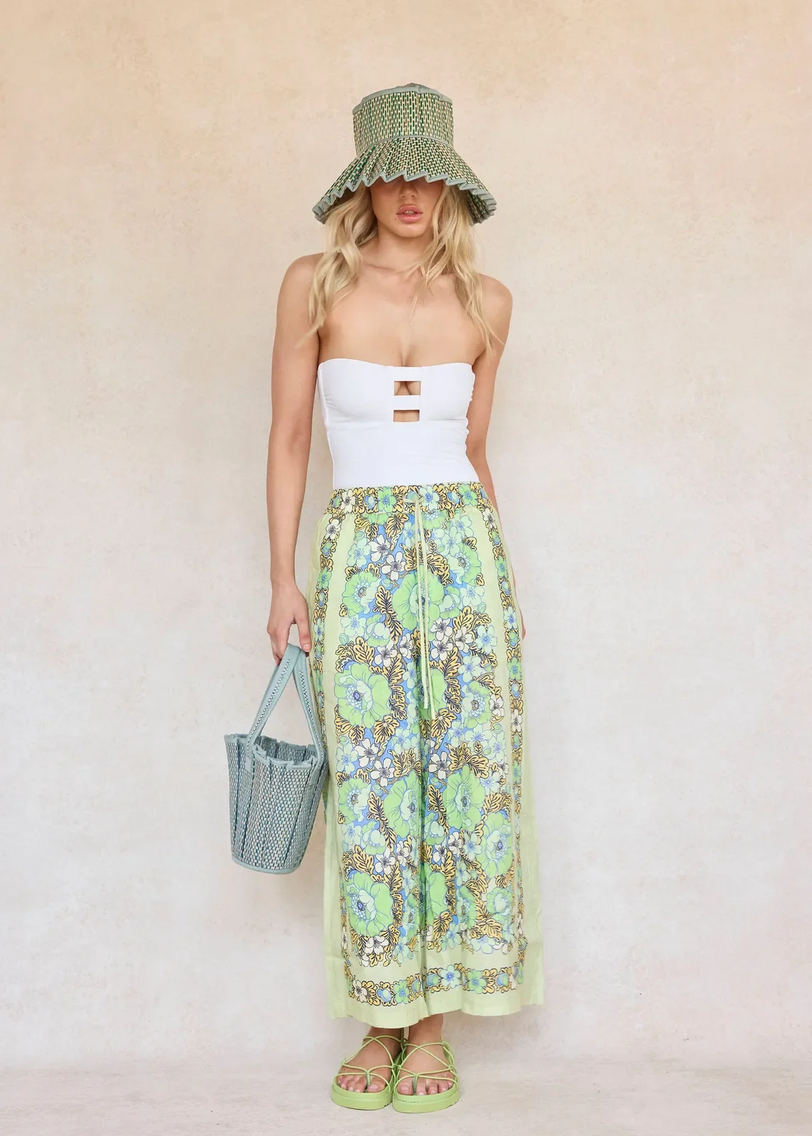 Model wearing the Lorna Murray Fiji Capri Hat, highlighting its elegant silhouette and handcrafted natural grass fibre weave.