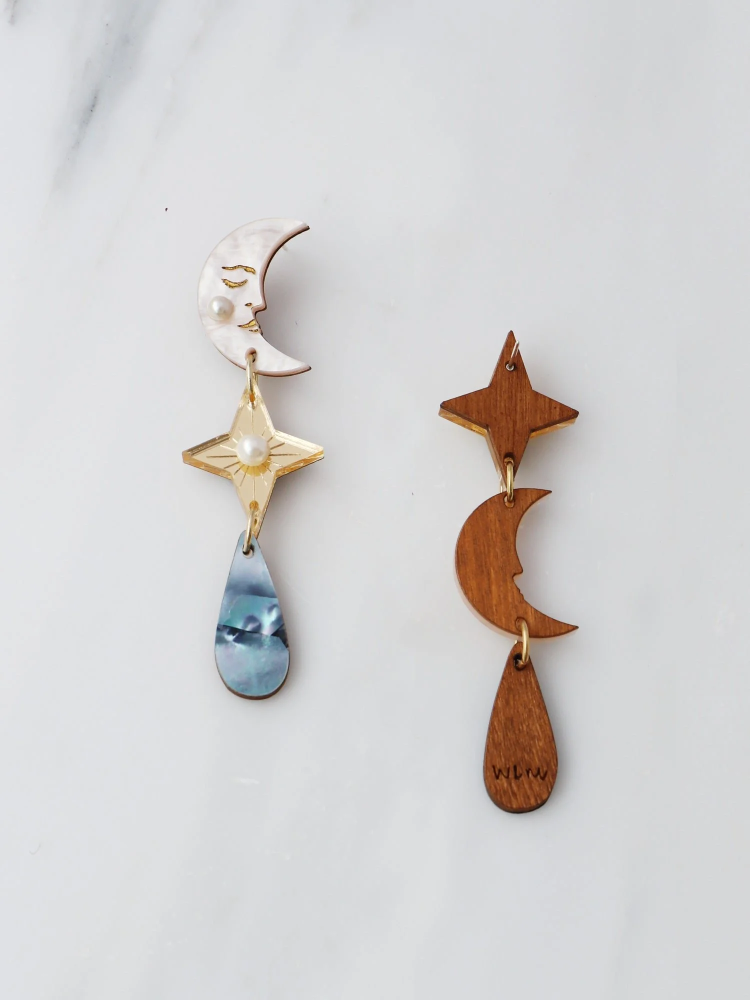Wolf & Moon 天體耳環，以壓克力與珍珠母製成，呈現月亮、星星與雨滴細節，設計為輕盈長款垂墜耳環。.