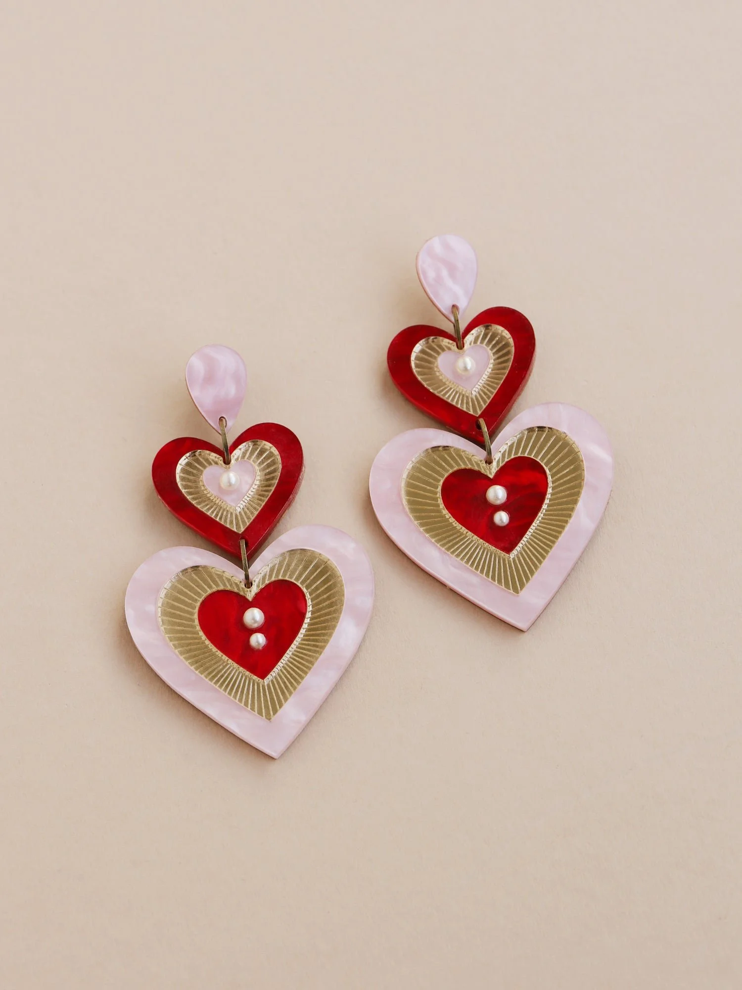 Wolf & Moon Ava 主張耳環，粉紅與紅色搭配層疊心形壓克力造型與玻璃珍珠細節。.