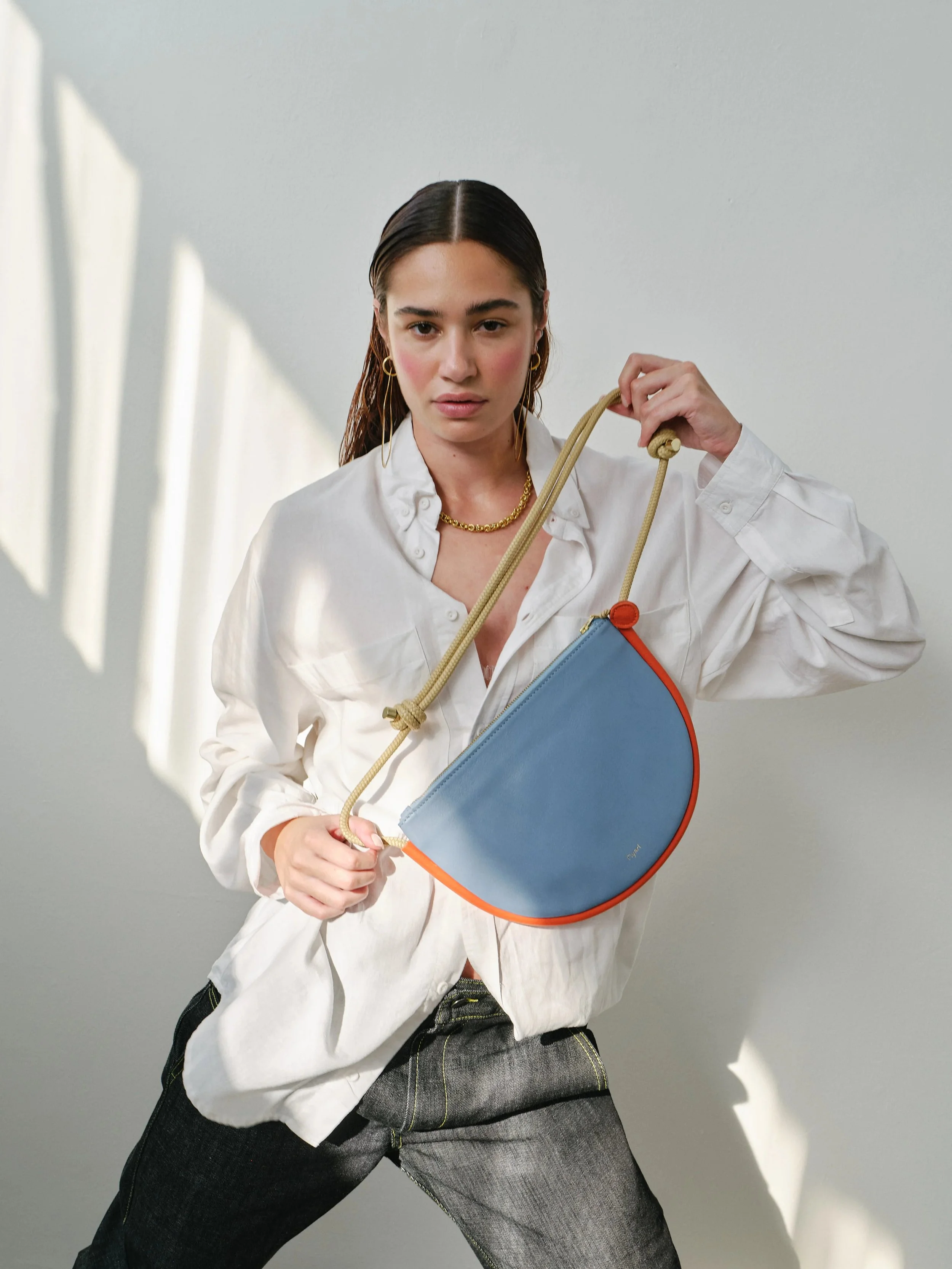 Selene Bag in sky blue and lobster red with folded silhouette, short handle and rope strap, handmade by Project Dyad in Cape Town.