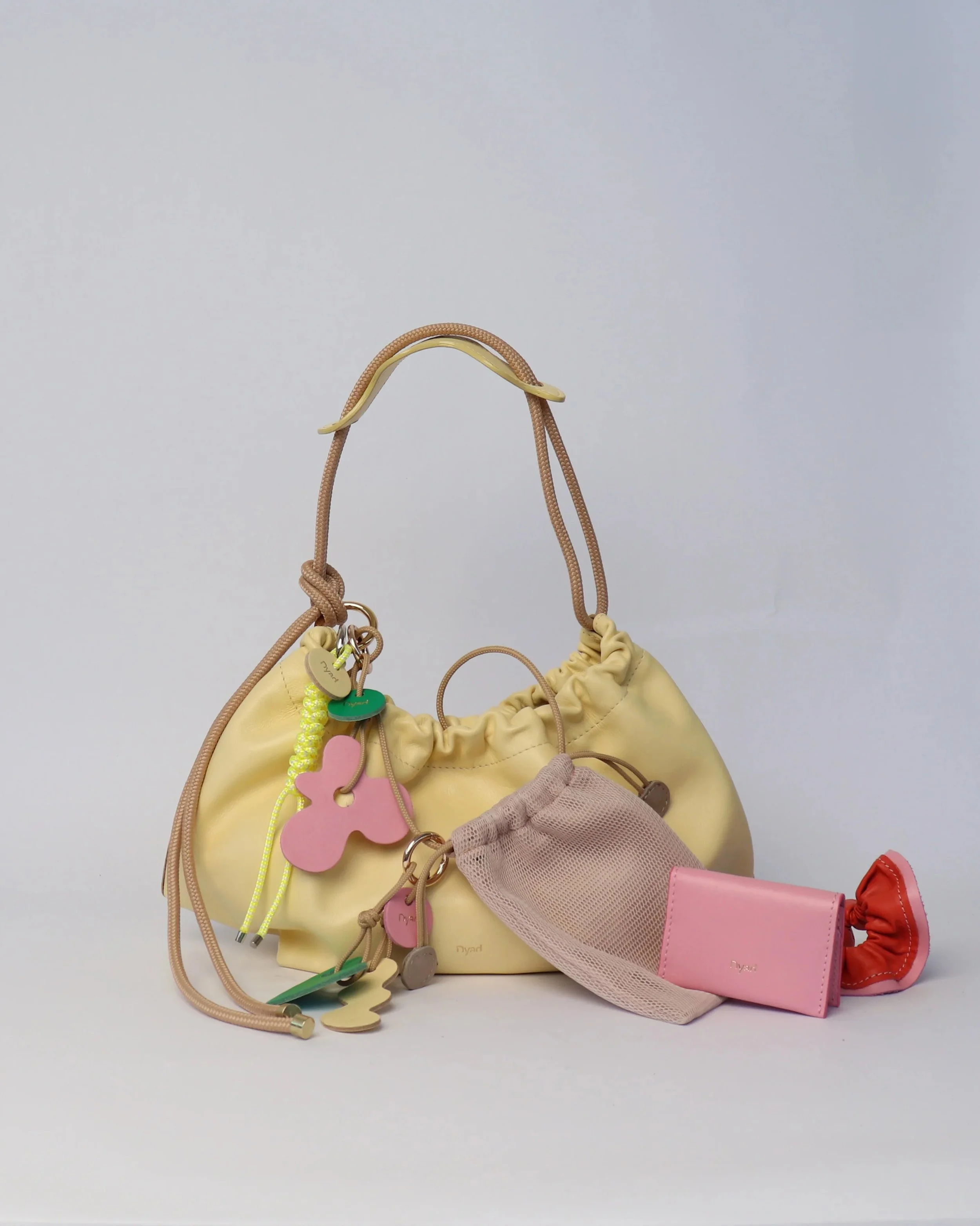 Butter yellow Flora Bag with tulip-style opening, handcrafted leather and adjustable rope strap by Project Dyad.