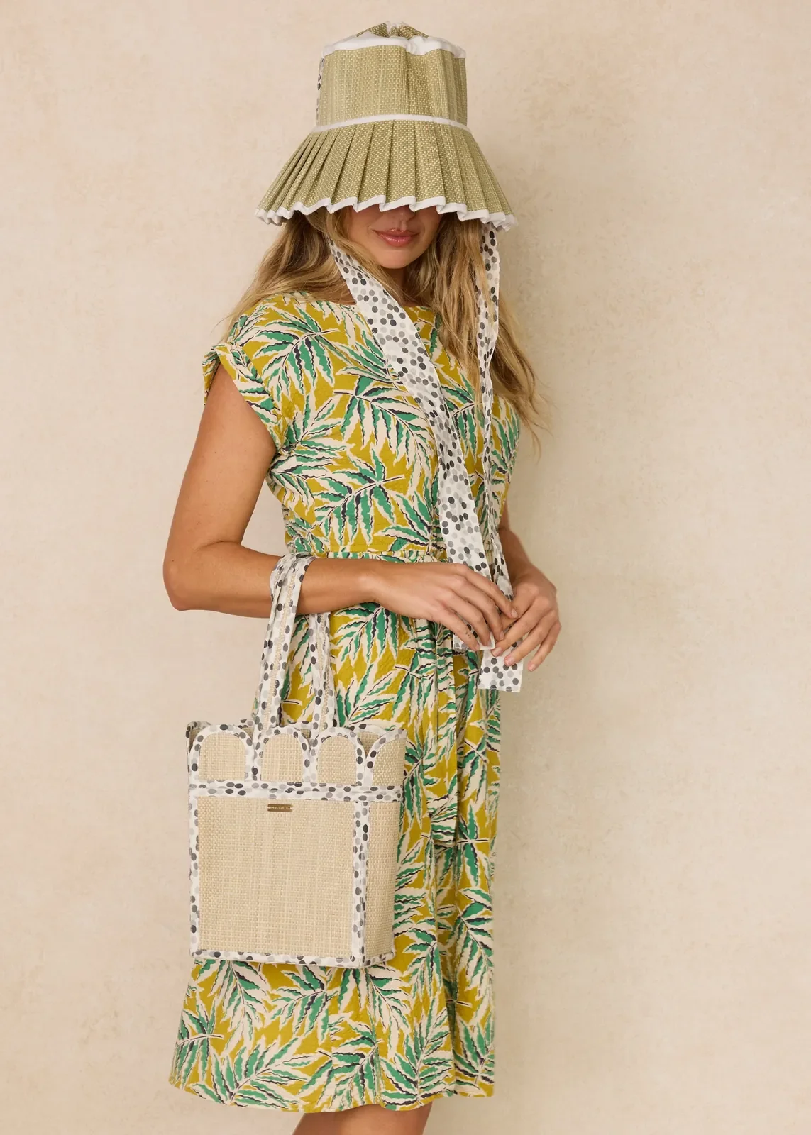 Model carrying the Lorna Murray Polka Monochrome Mini Scallop Tote, showcasing its lightweight handcrafted woven design.
