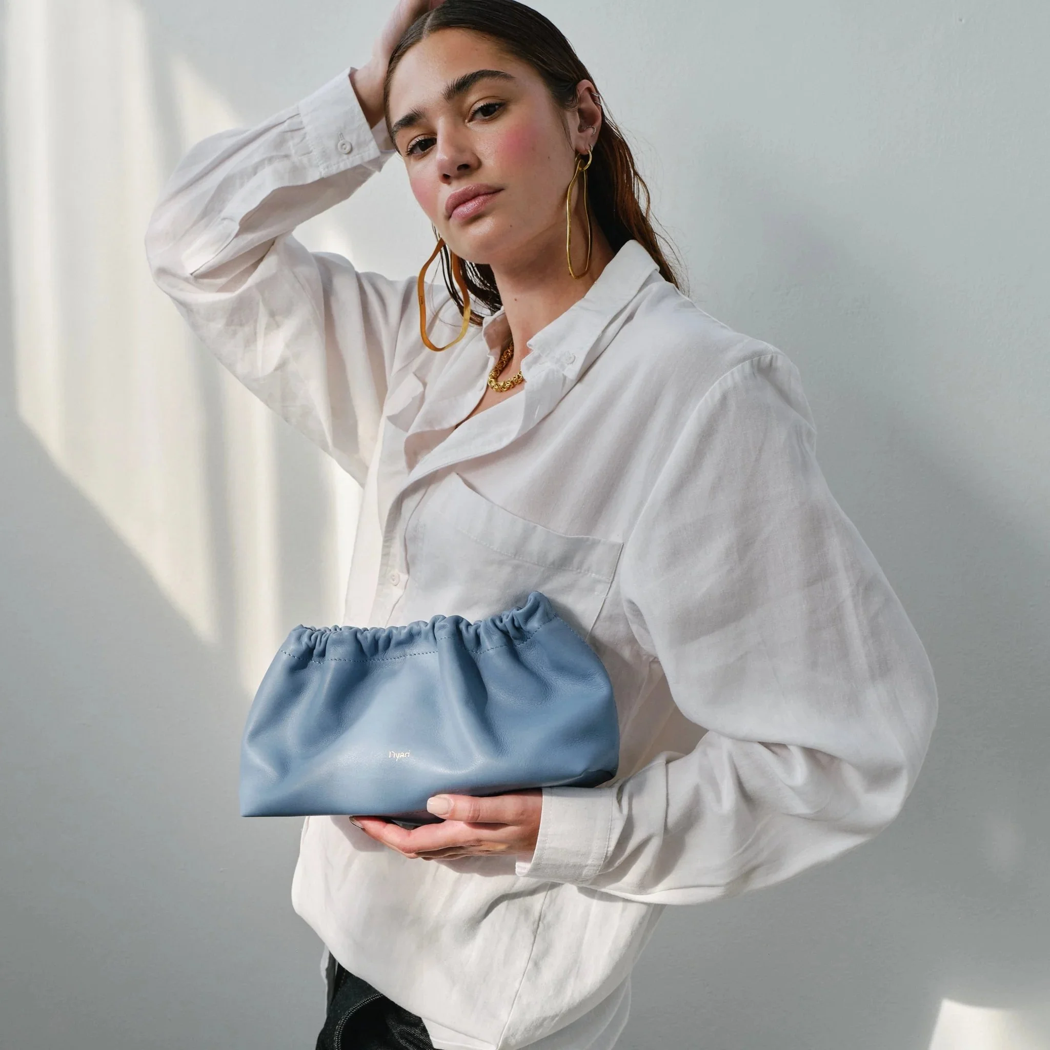 Wave Bag in sky blue with soft crescent shape, short handles and bonded cotton lining, handmade by Project Dyad in Cape Town.