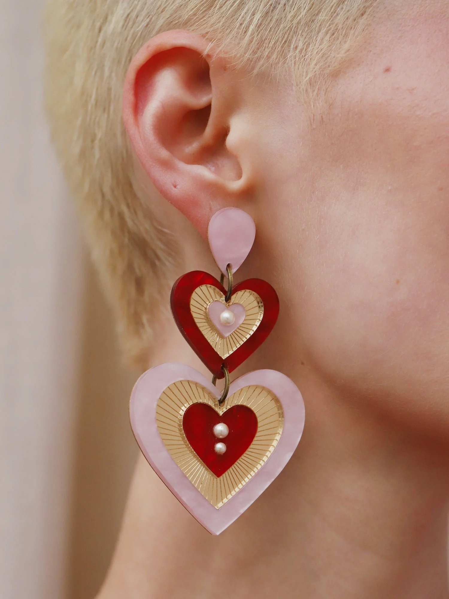 Wolf & Moon Ava 主張耳環，粉紅與紅色搭配層疊心形壓克力造型與玻璃珍珠細節。.