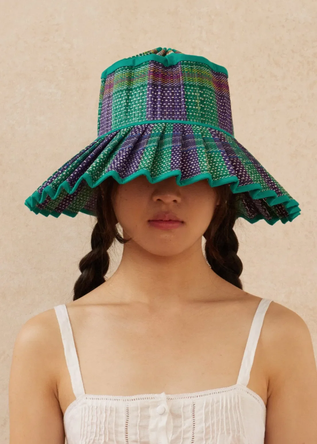 Model wearing the Lorna Murray Mexico Island Capri Hat, showcasing its handcrafted woven design, wide brim and colourful striped pattern.