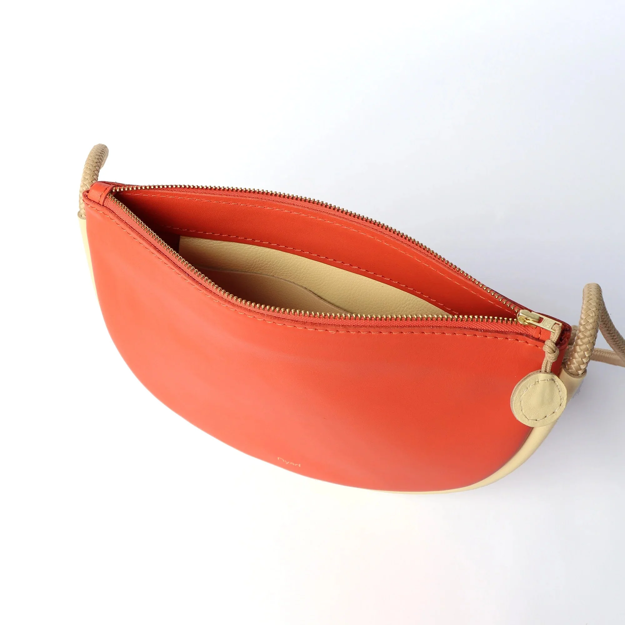 Selene Bag in Lobster Red and Butter – handcrafted leather sling bag with crescent shape and adjustable rope strap, designed by Project Dyad