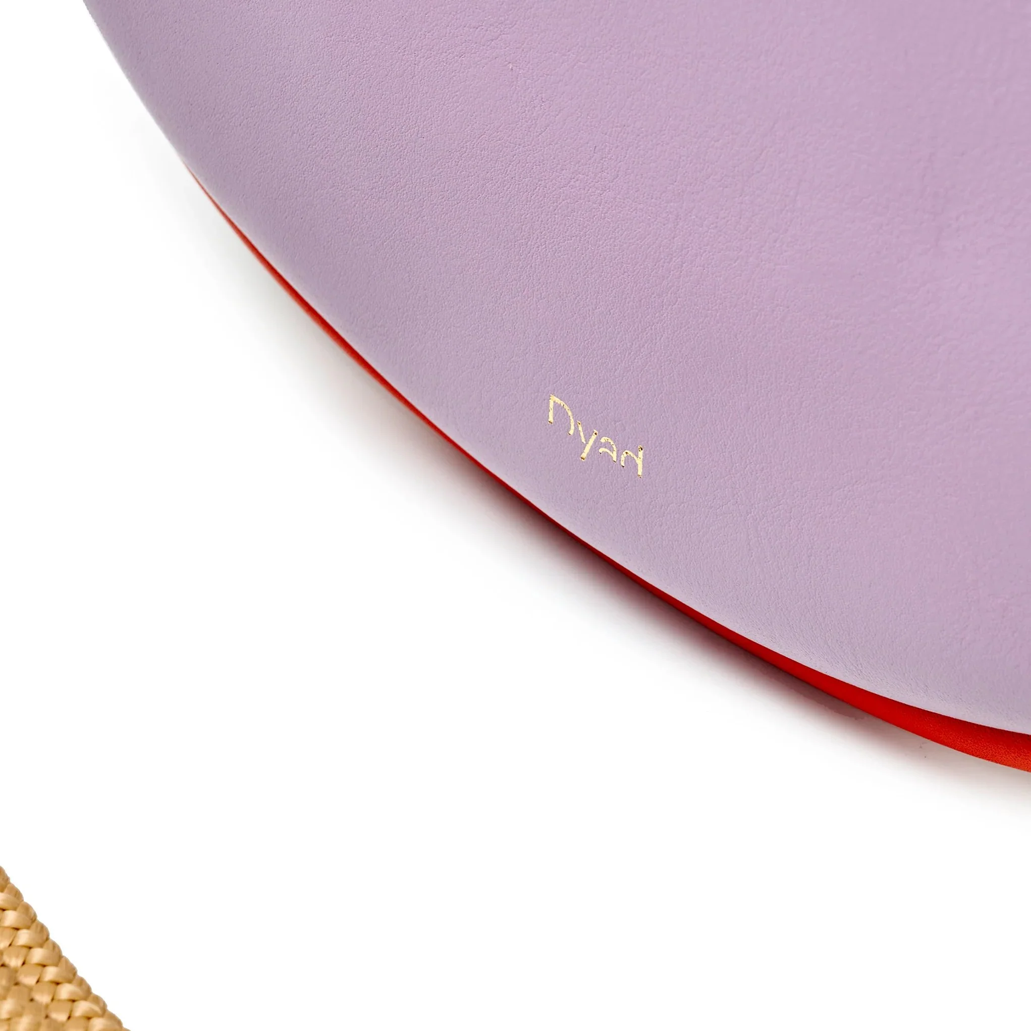 Selene Bag in lilac and lobster red colourway, folded sculptural design with short handles and removable strap, photographed in daylight.