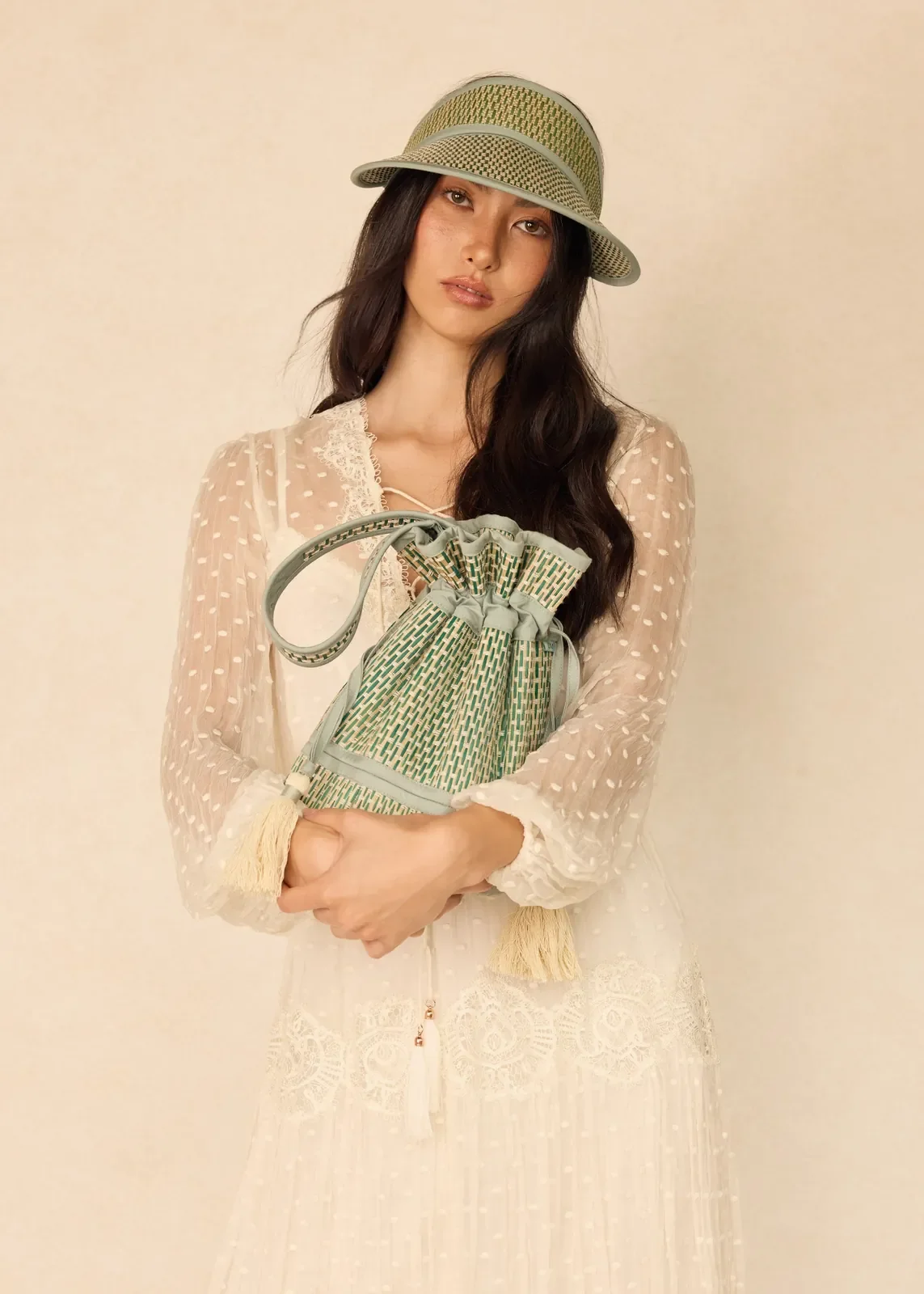 Model carrying the Lorna Murray Fiji Mini Leisure Tote, showcasing its lightweight handcrafted drawstring design.