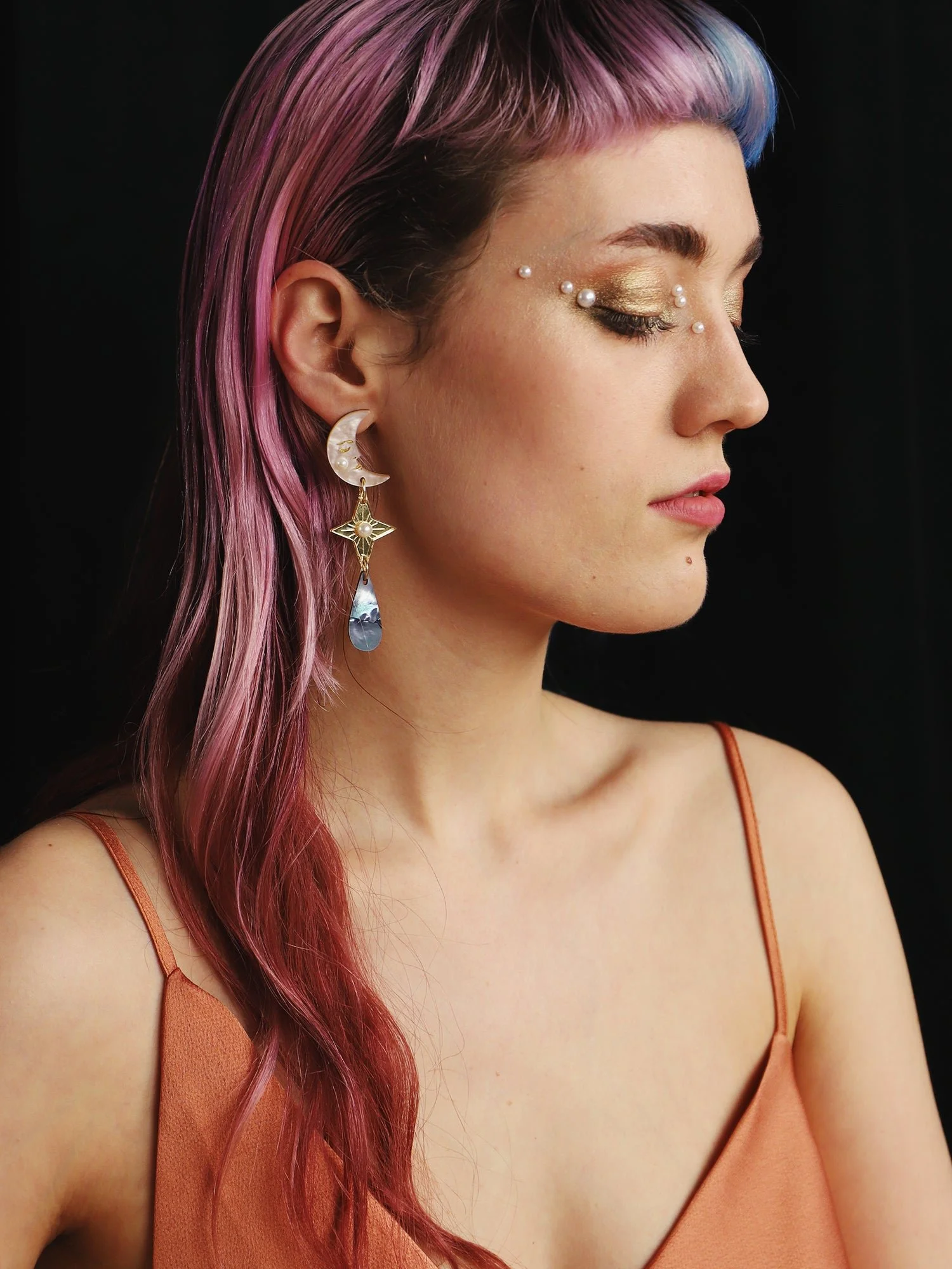 Wolf & Moon 天體耳環，以壓克力與珍珠母製成，呈現月亮、星星與雨滴細節，設計為輕盈長款垂墜耳環。.