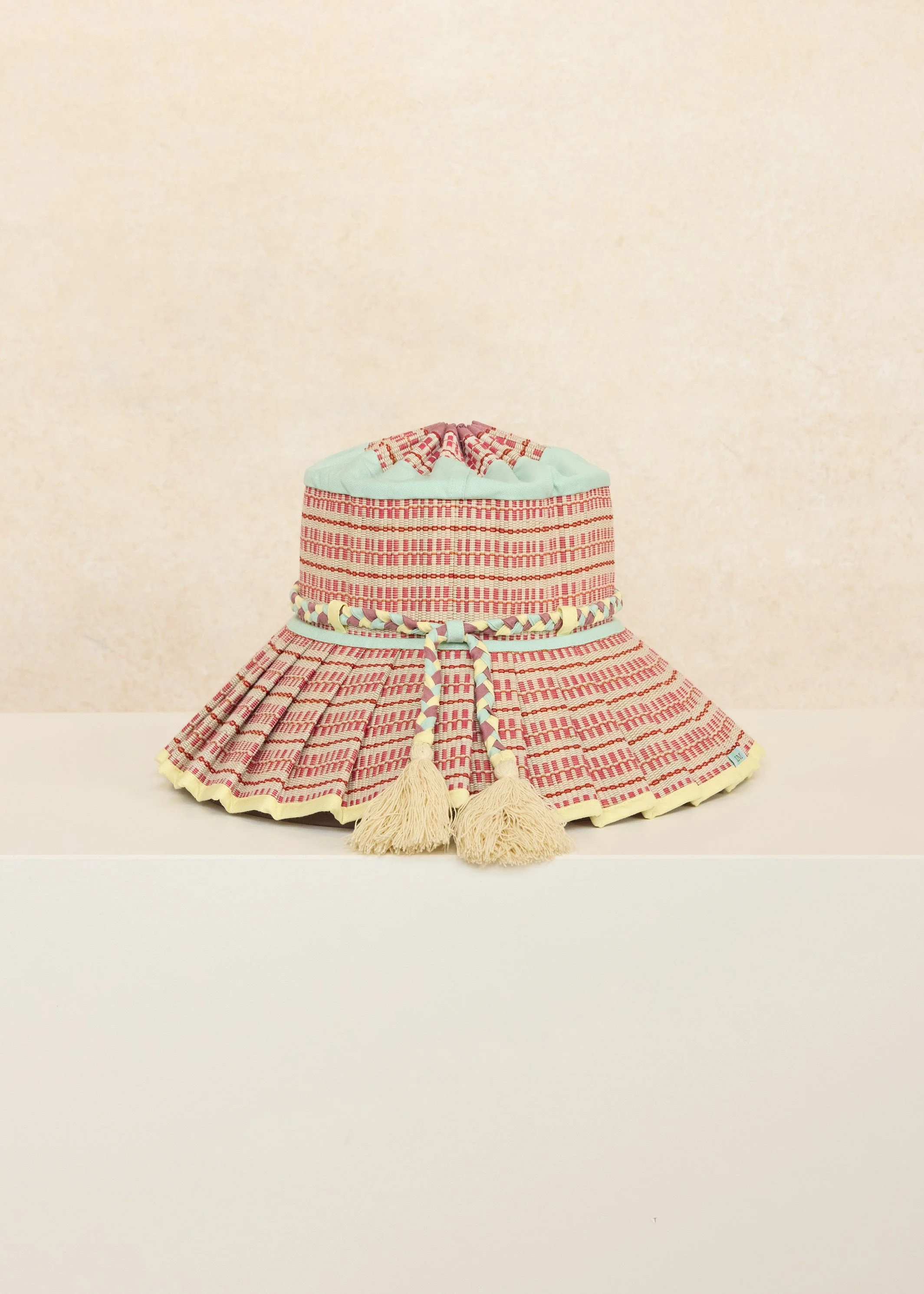 Angled front view of the Lorna Murray Procida Island Florence Hat showcasing its colourful woven design and braided fabric tie.
