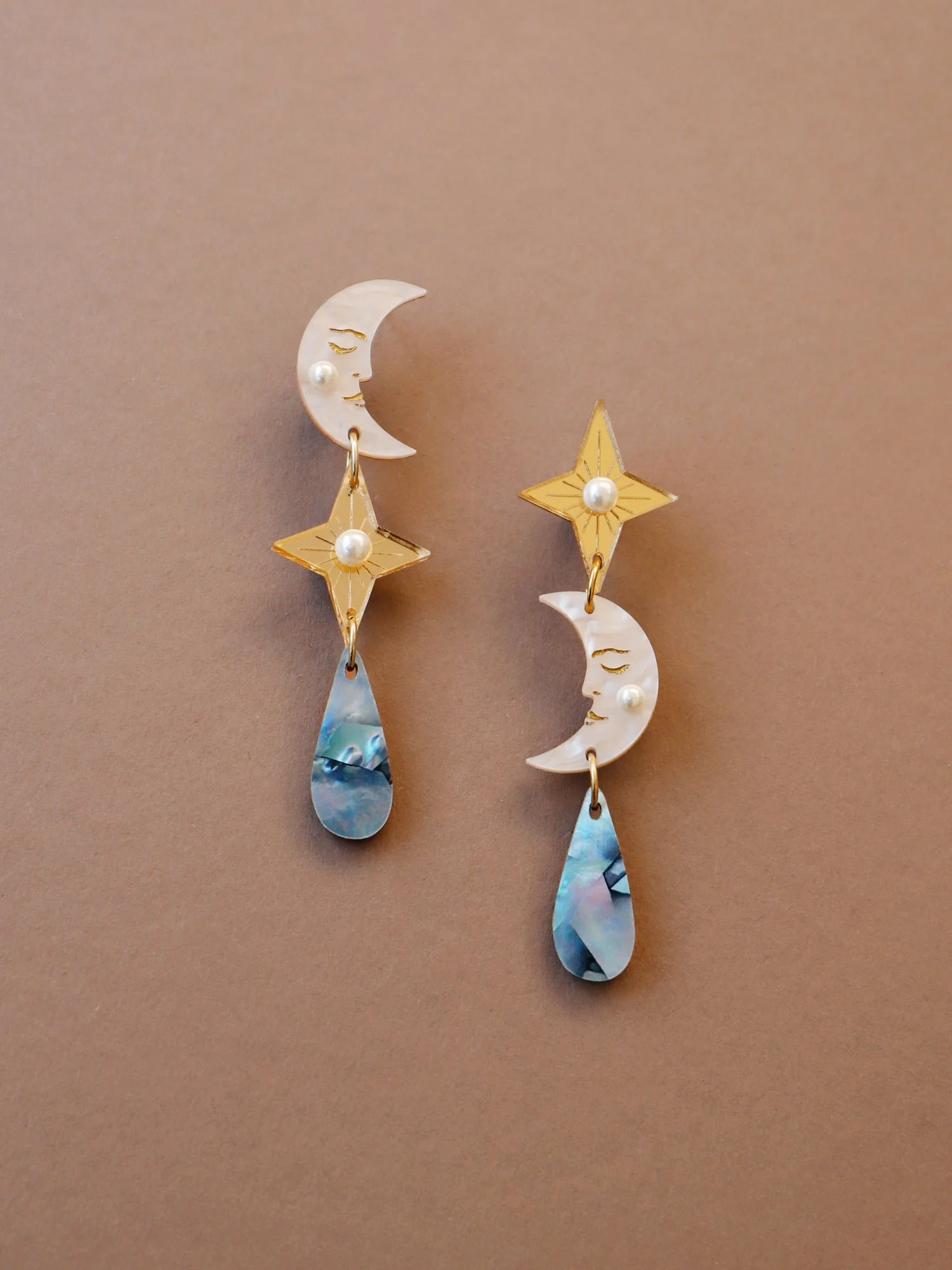 Wolf & Moon 天體耳環，以壓克力與珍珠母製成，呈現月亮、星星與雨滴細節，設計為輕盈長款垂墜耳環。.