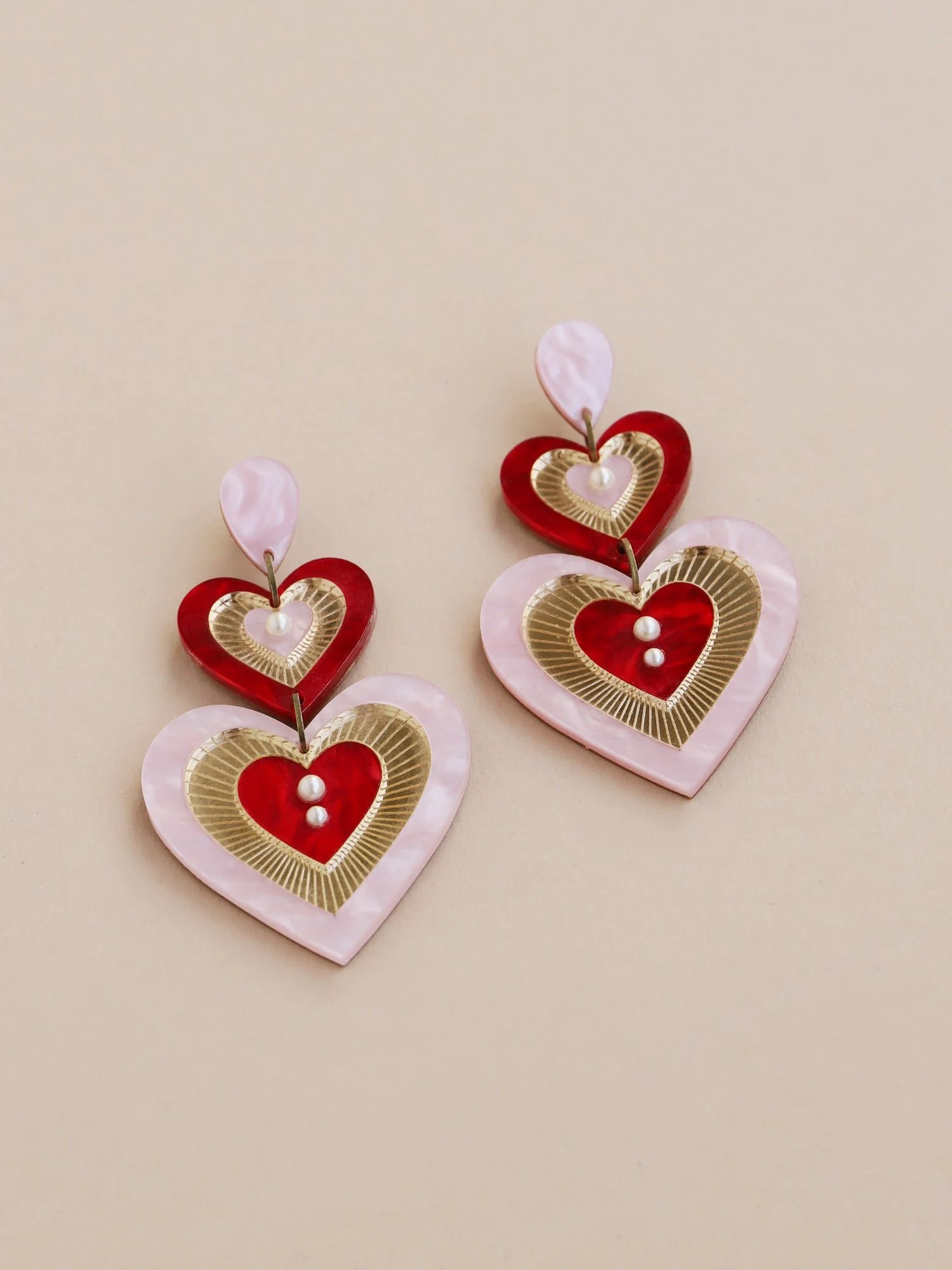 Wolf & Moon Ava 主張耳環，粉紅與紅色搭配層疊心形壓克力造型與玻璃珍珠細節。.