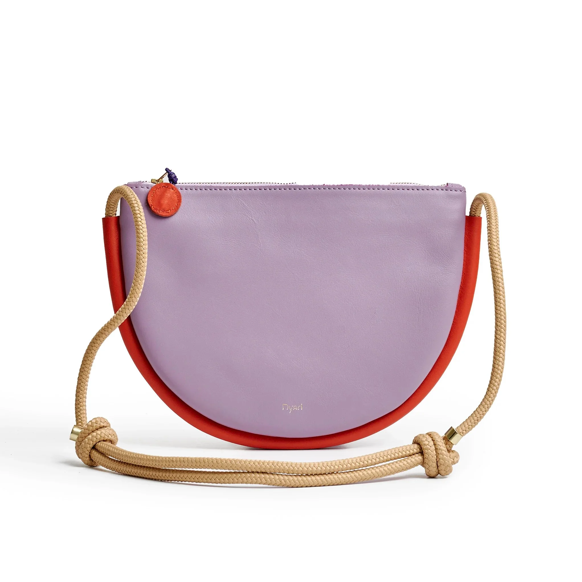 Selene Bag in lilac and lobster red colourway, folded sculptural design with short handles and removable strap, photographed in daylight.