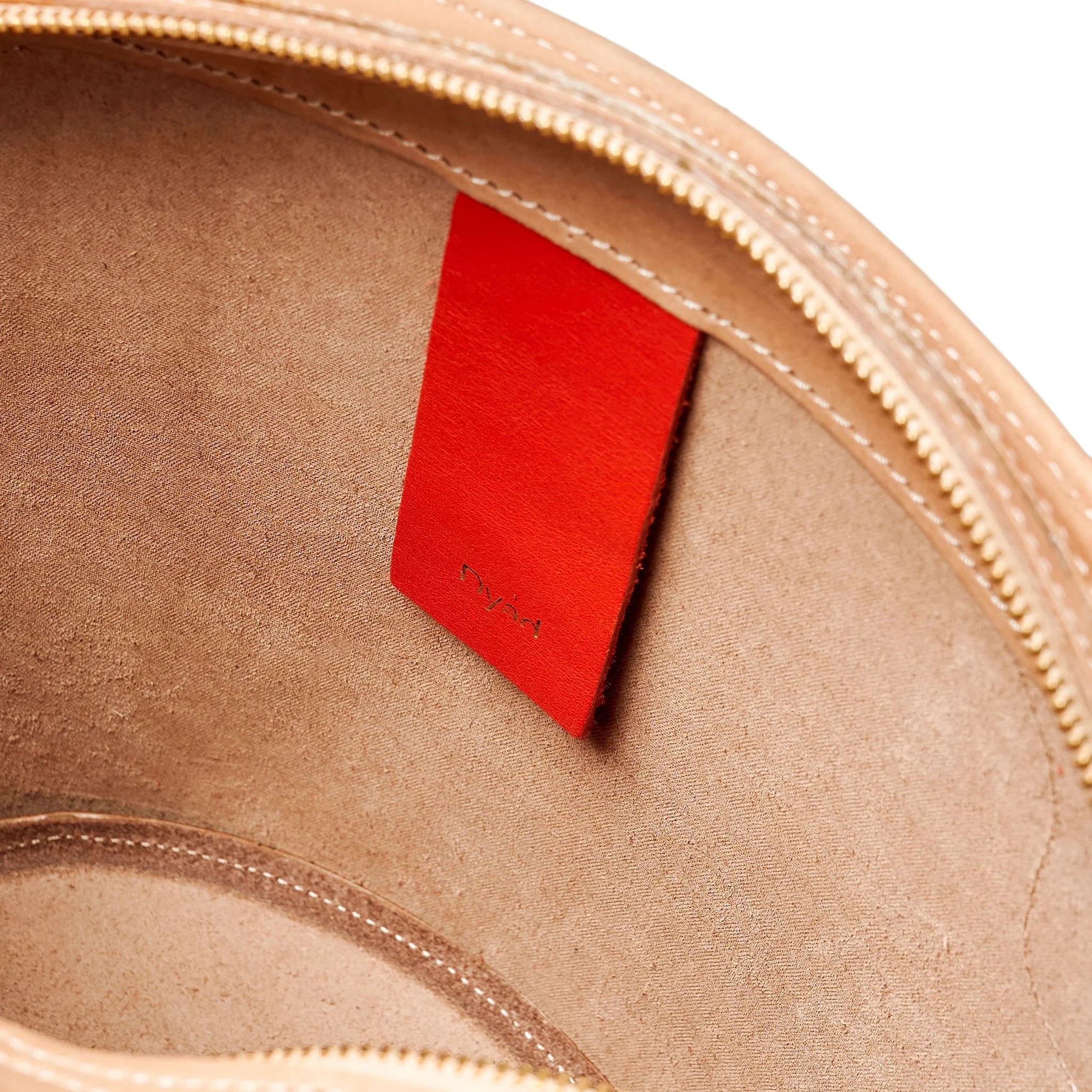 Almond and lobster red Emele Bag by Project Dyad, handmade in Cape Town with a curved silhouette and structured pleats.