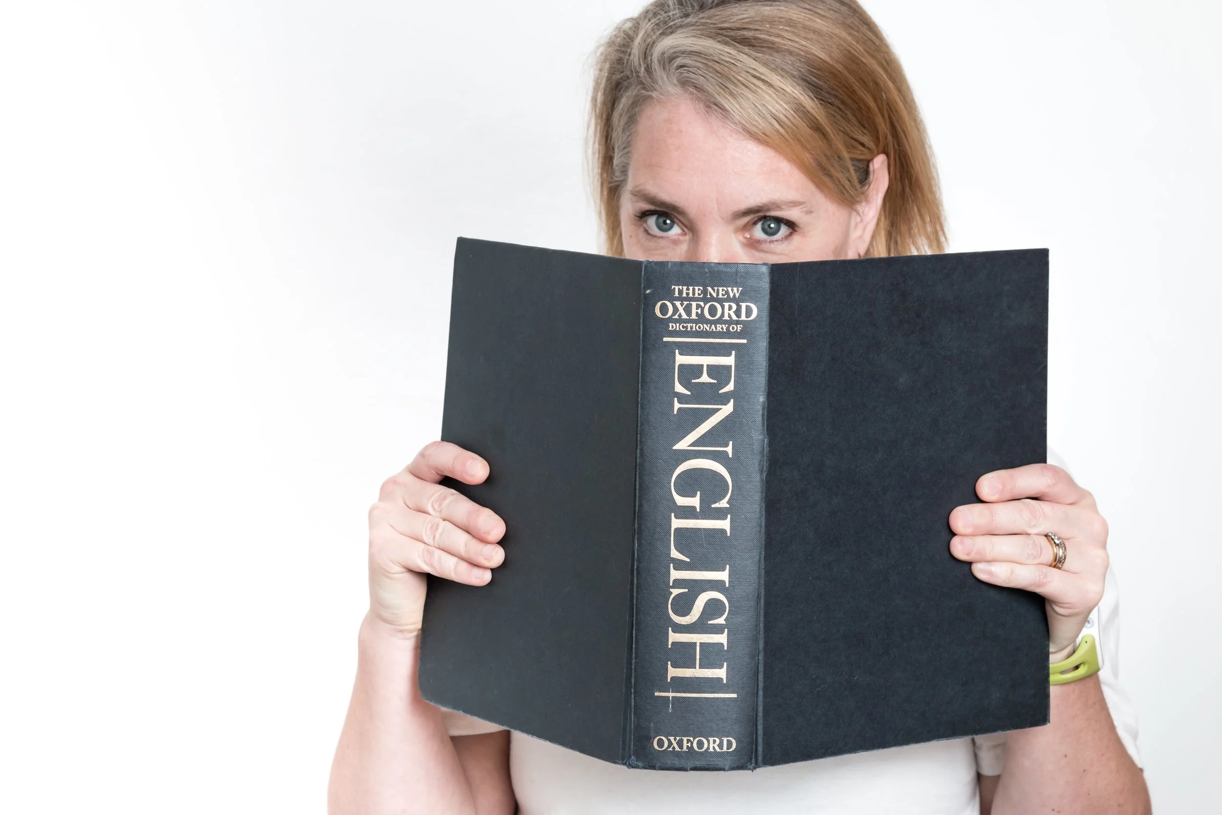 Woman hidinh behind English dictionary - photograph by Sian T. Photography