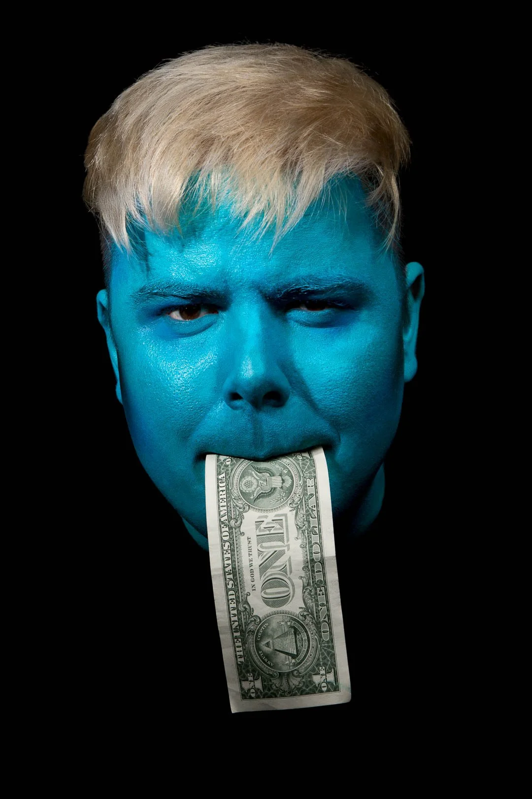 Man painted blue with dollar note in mouth taken by Sian T Photography