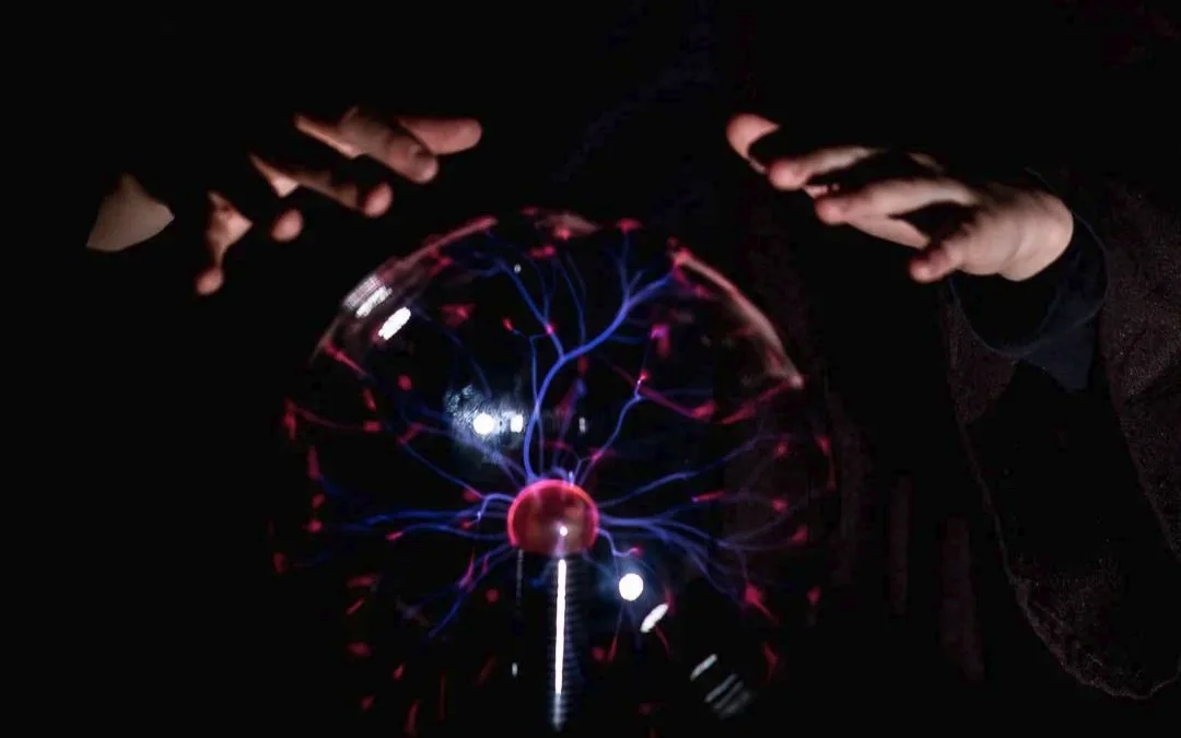 Plasma ball with a childs hands hovering over it