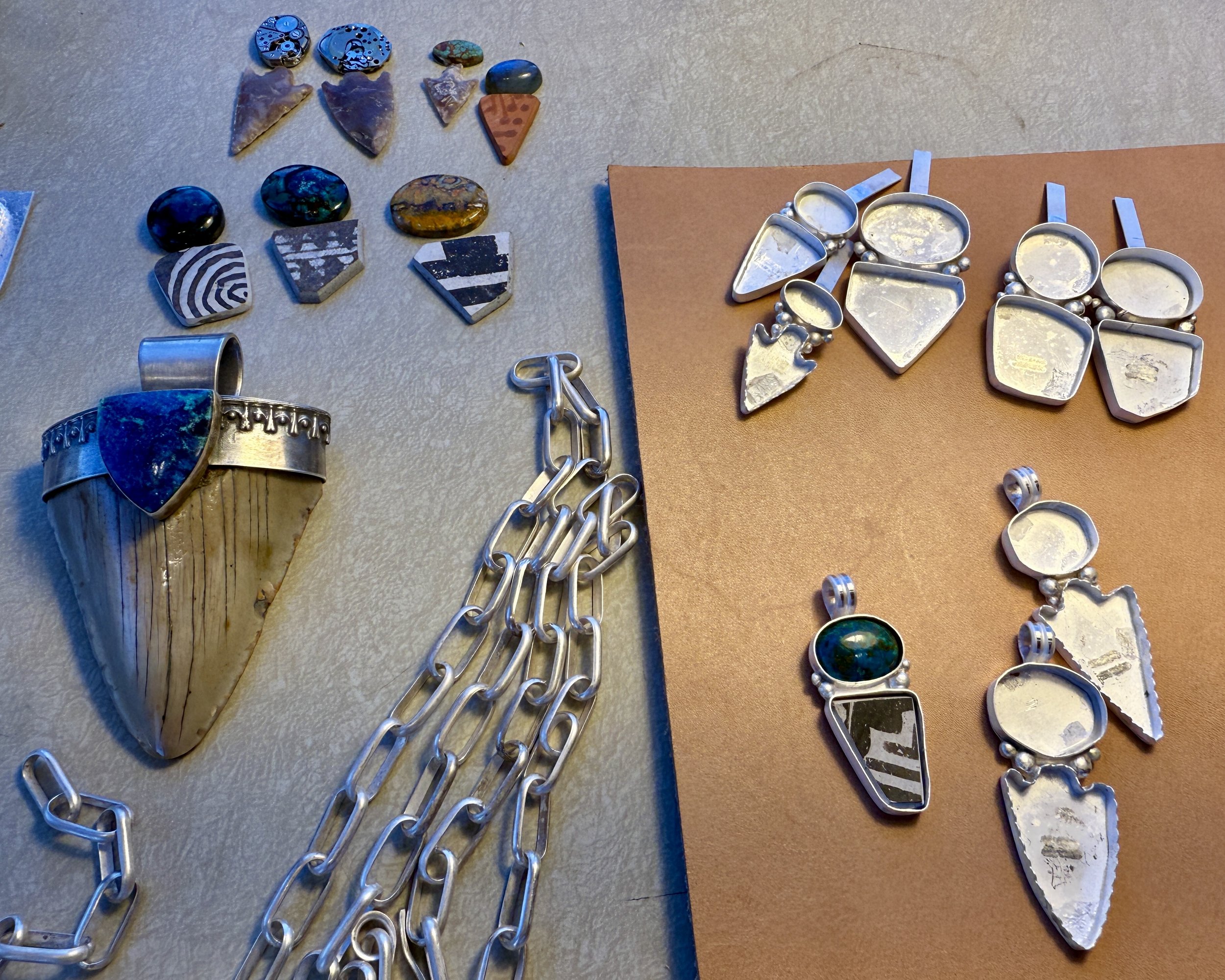 November 27, 2025 - I've just finished this megalodon shark tooth pendant with a handmade chain and am working on something new, a group of pendants made with arrowheads and pottery shards. I was an archeologist before I was a silversmith, and I have