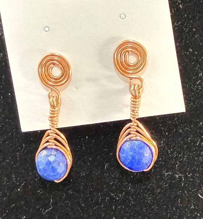 808-26;Earrings;’BCuStudSpiralHoldingDeepBlueStoneBead’;UniqueHandCraftedFreeFormBCuClosedSpiralStud;SuspendingAUniqueHandCraftedFreeFormBCuUpwardAlternatingHalfVerticalSpiralWireWrapDongleHoldingAGorgeousDeepBlueFacettedRoundStoneBead;NoEarHookRequi