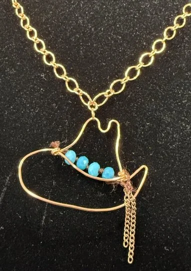 784-26;Necklace;’CowboyHatWithBlueBeadLeatherHeadBand’;AnOriginalJonMichelleDesign;UniqueHandCraftedFreeFormBriteCuRoundWireCowboyHatShilouetteWithLightBlueSeedBeadOnLeatherHeadBand;Chain24Inch;BrightCuTinyOvalWithLargerOvalInterlockingLinks;A2"(Inch