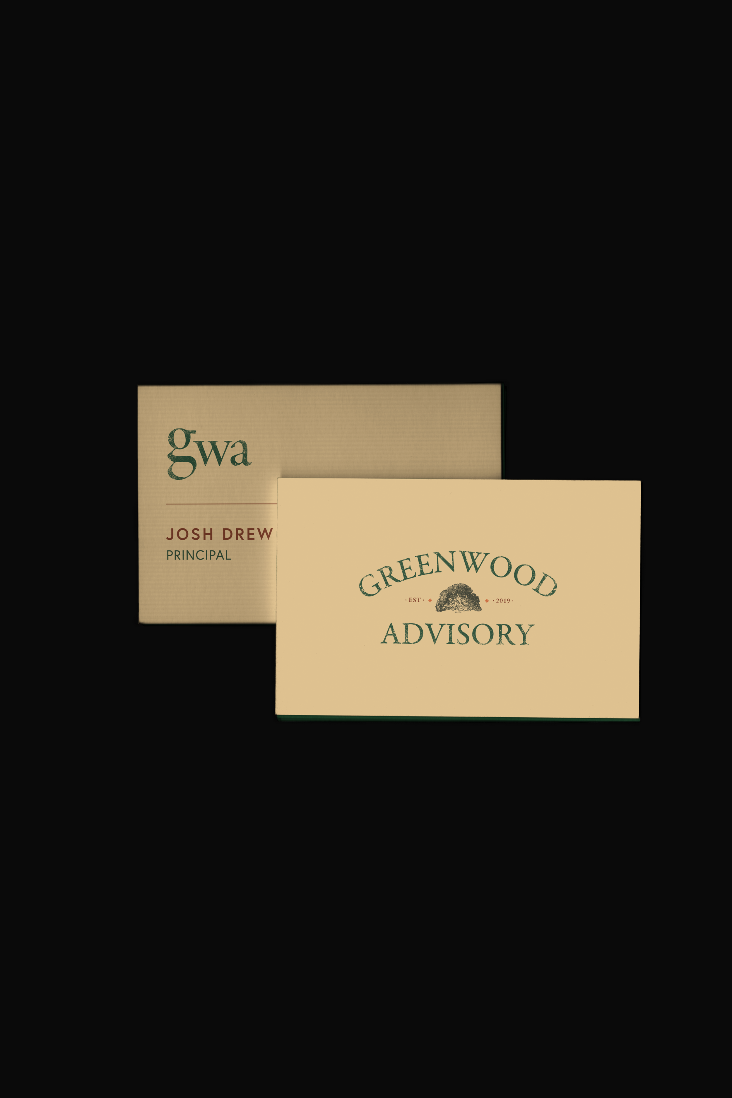 Two business cards against a black background. The card in front reads "GREENWOOD ADVISORY" with a tree illustration, and the card behind reads "Gwa JOSH DREW PRINCIPAL."