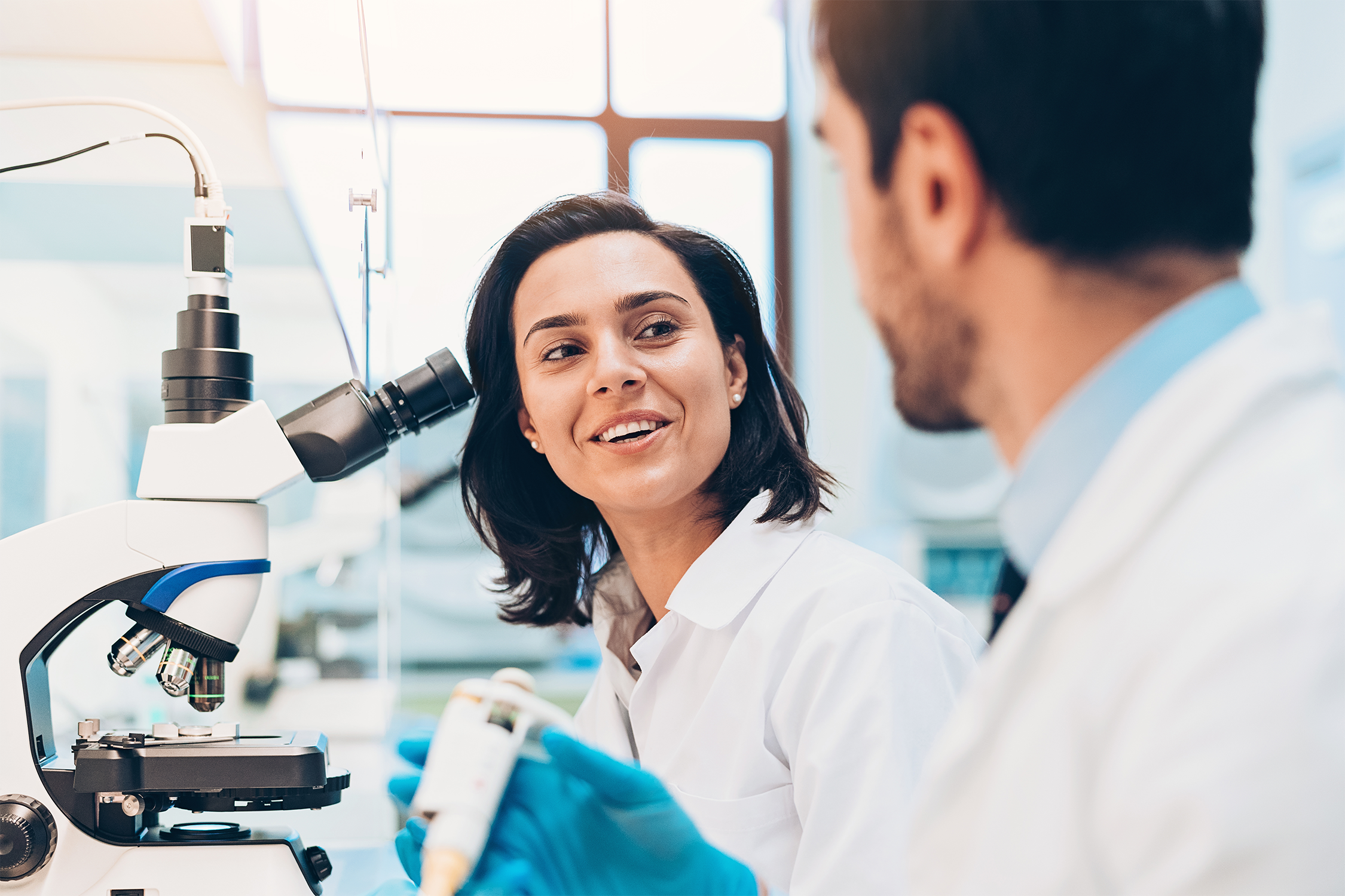 05 Scientists Talking Next to Microscope.png