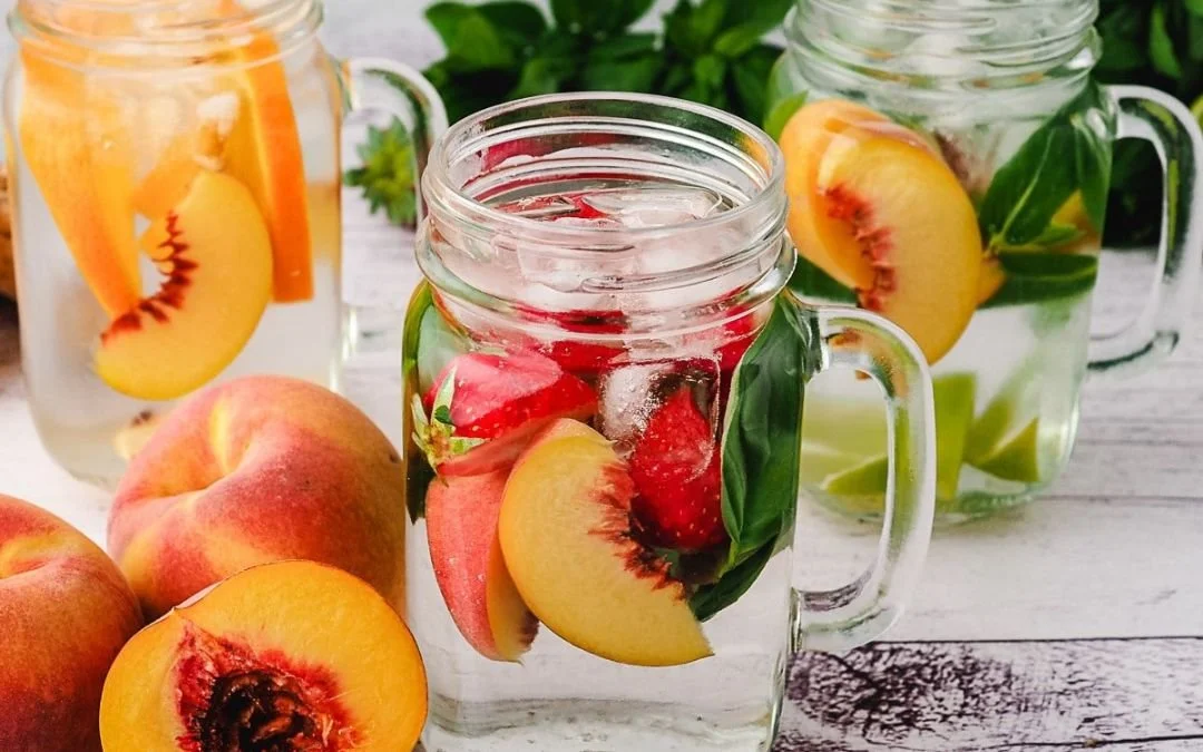 3 glass mugs of ice water infused with fruit and herbs