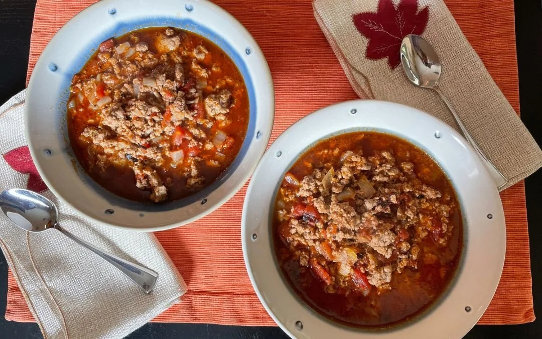 2 bowls of turkey chili on placemat with napkins and spoons