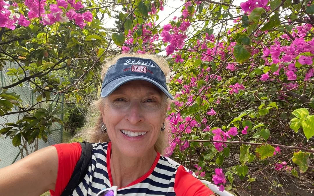 kathie cude wearing st kitts hat with flowering tree background
