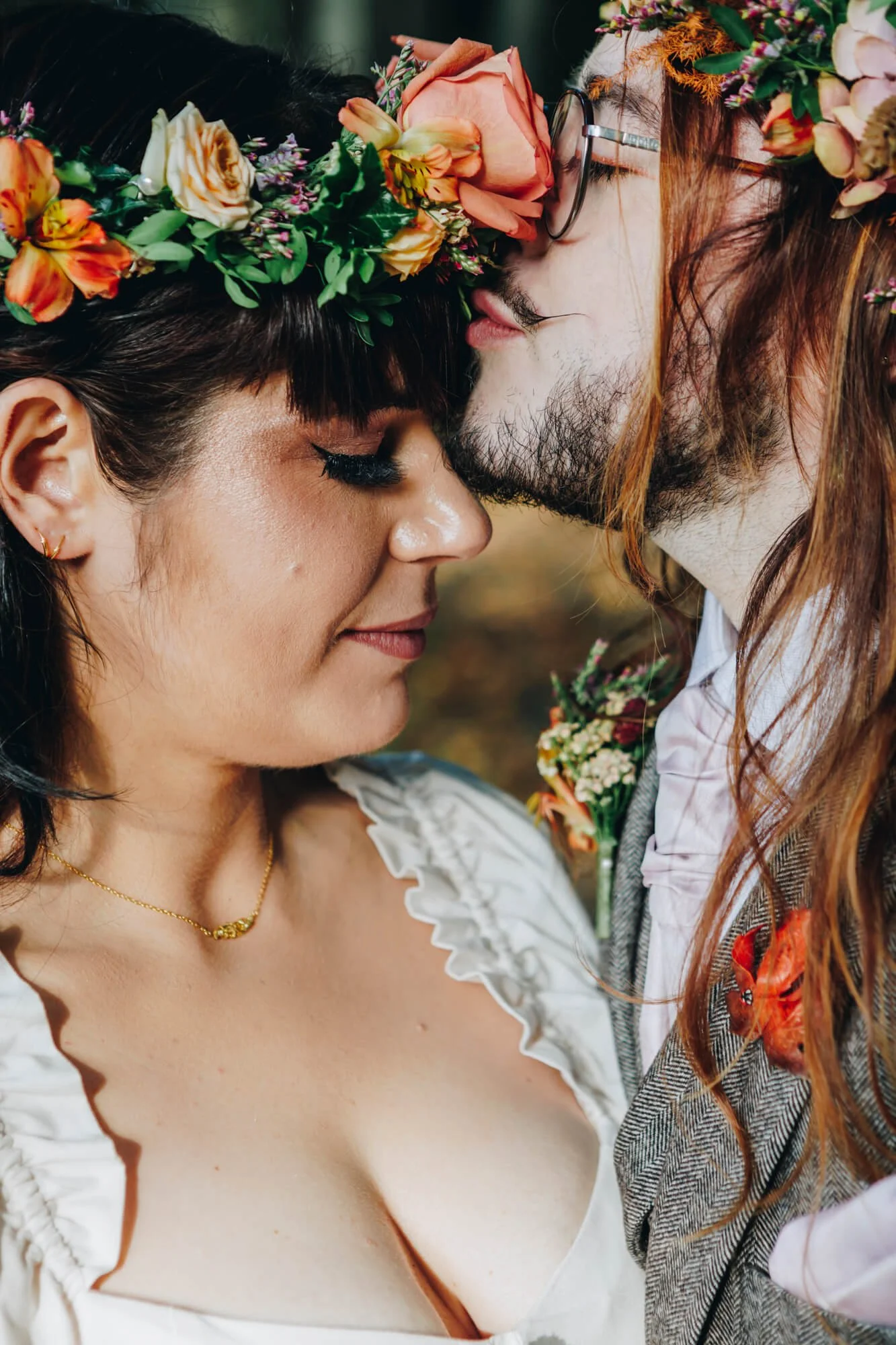 A couple with flower crowns sharing a tender moment with foreheads touching. Alnwick Treehouse wedding photography
