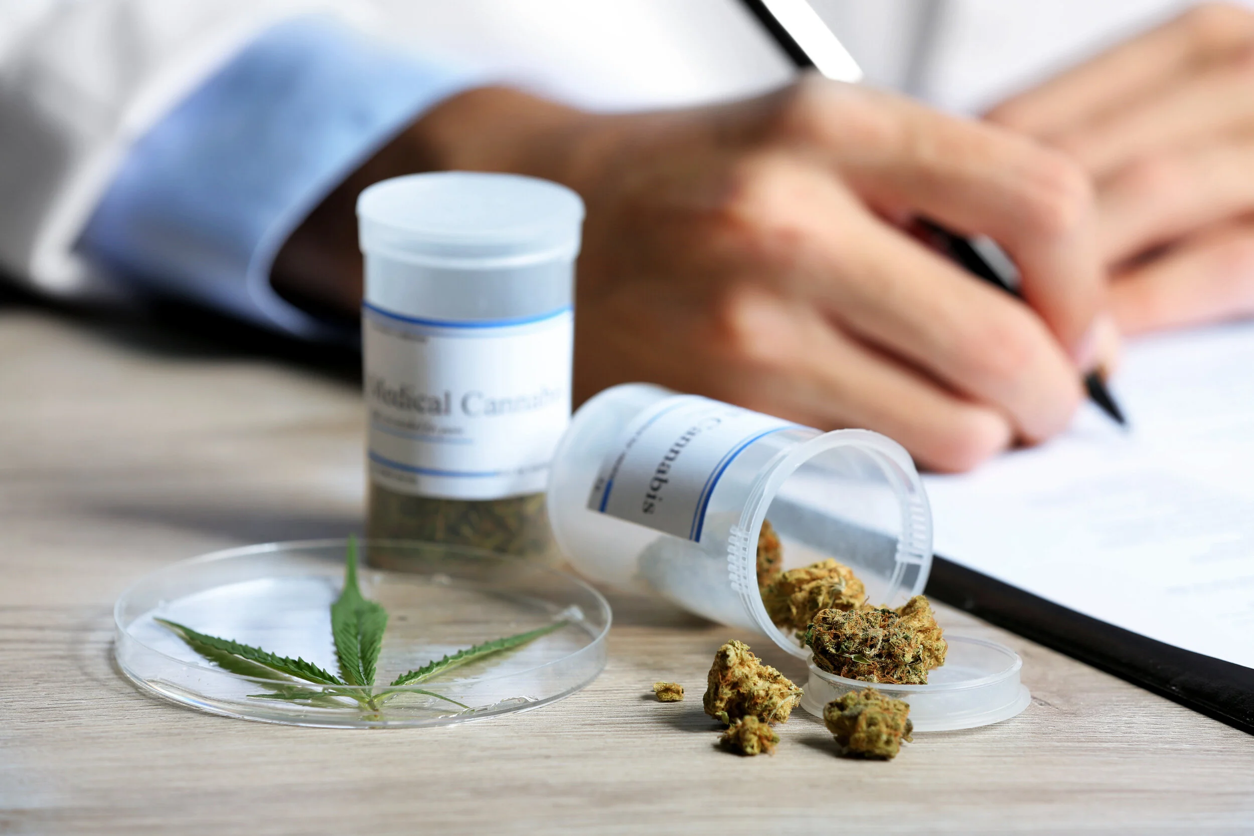 Doctor writing on prescription for medicinal cannabis.