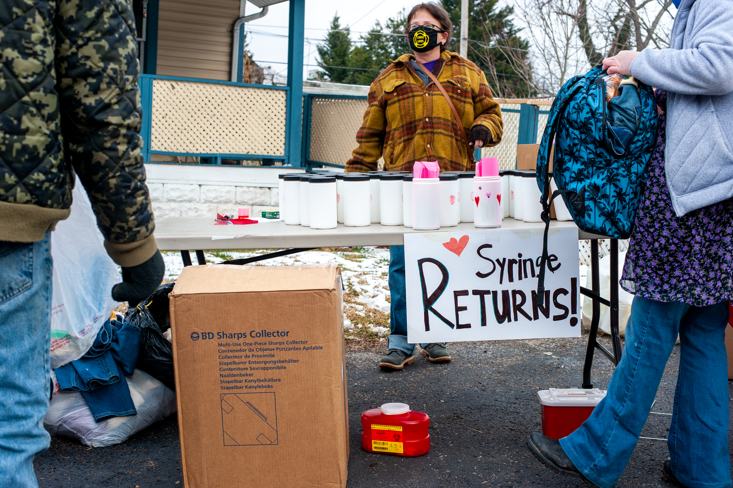 A woman takes a container of used syringes out of her backpack to turn in at a harm reduction event in Charleston, W.Va.&nbsp; Feb. 20, 2021. (Photo/Kyle Vass)