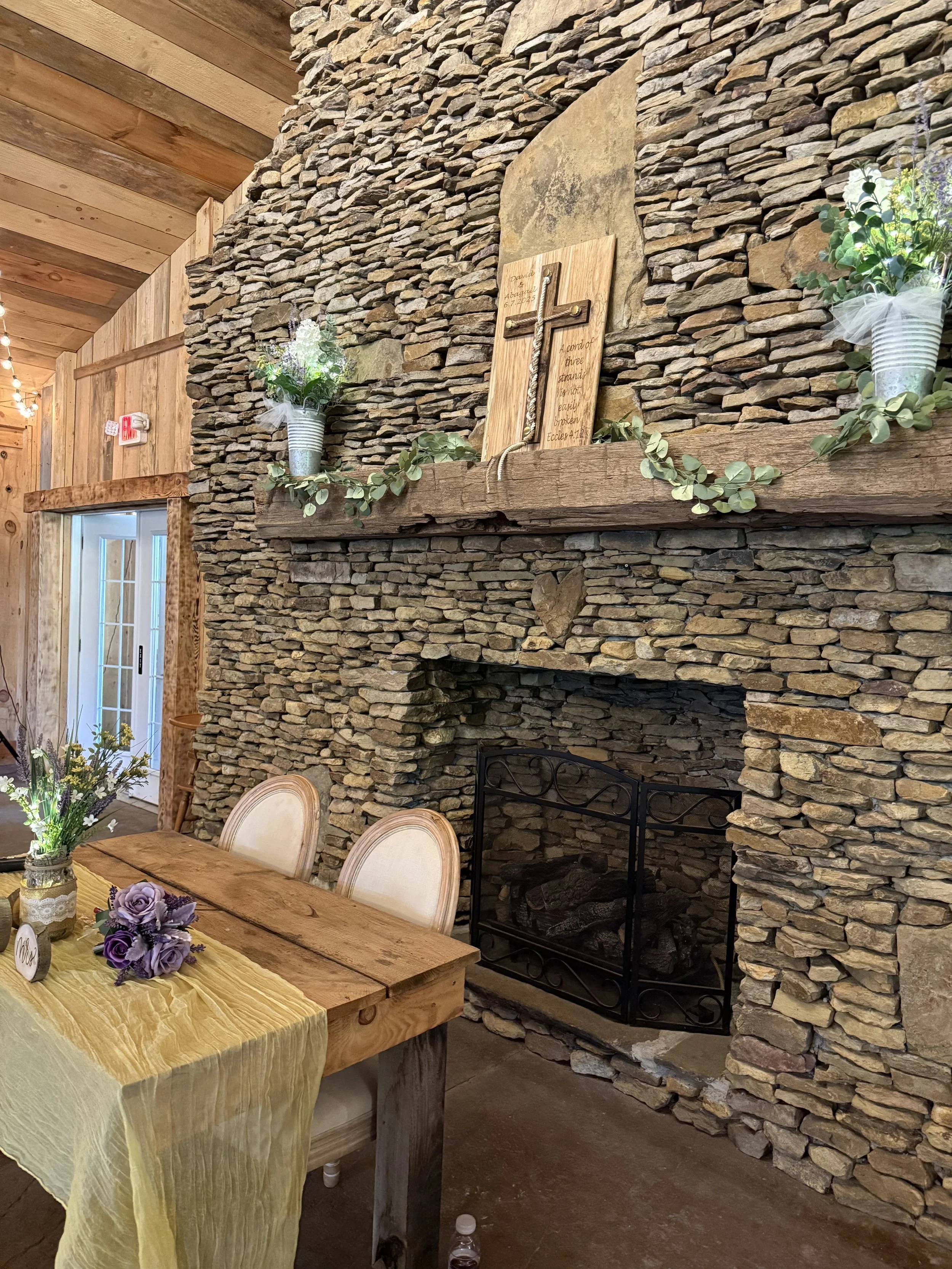 sweetheart table in front of stone fireplace 