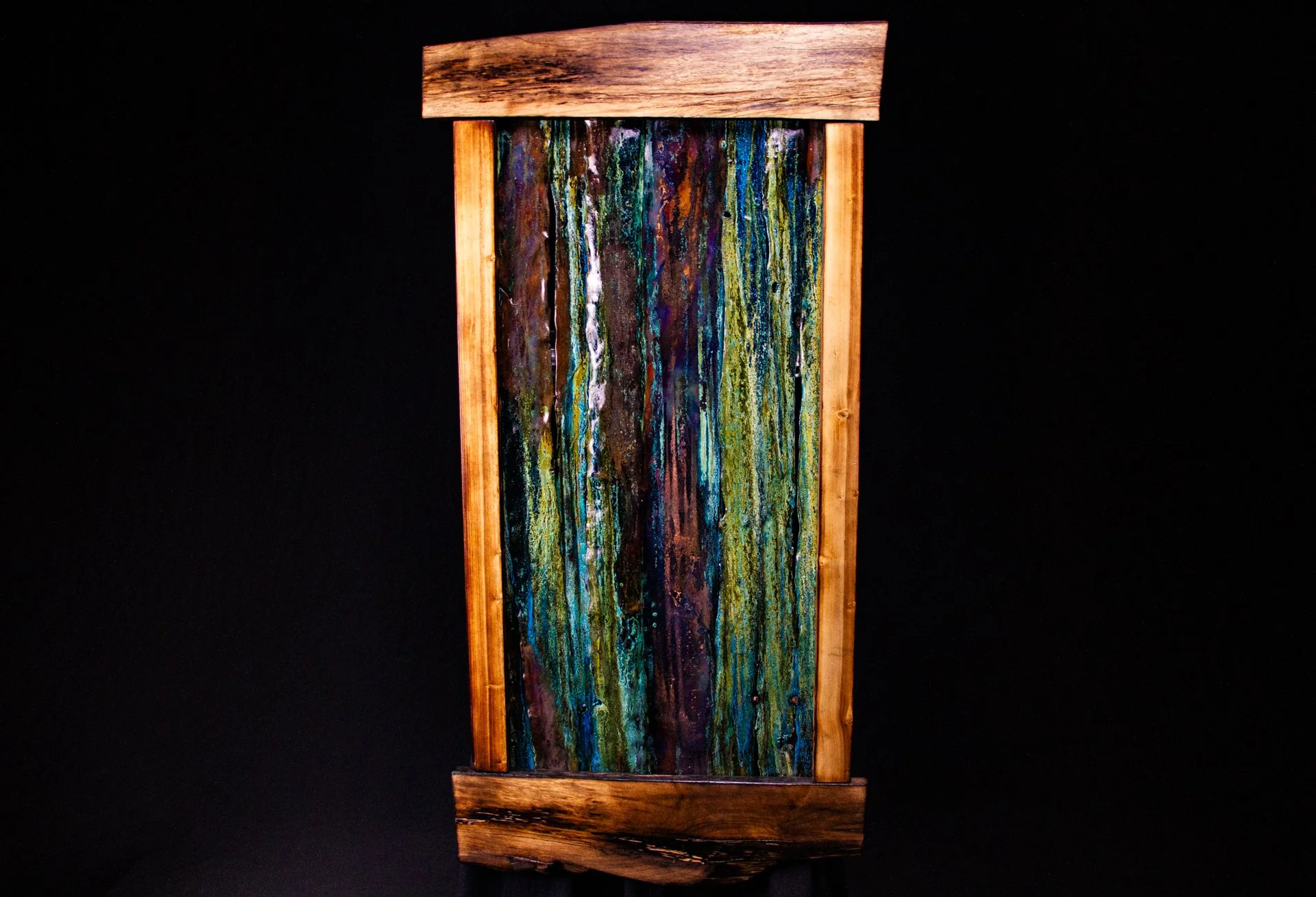 Colorful abstract copper artwork framed with wood and colored with natural copper patina.