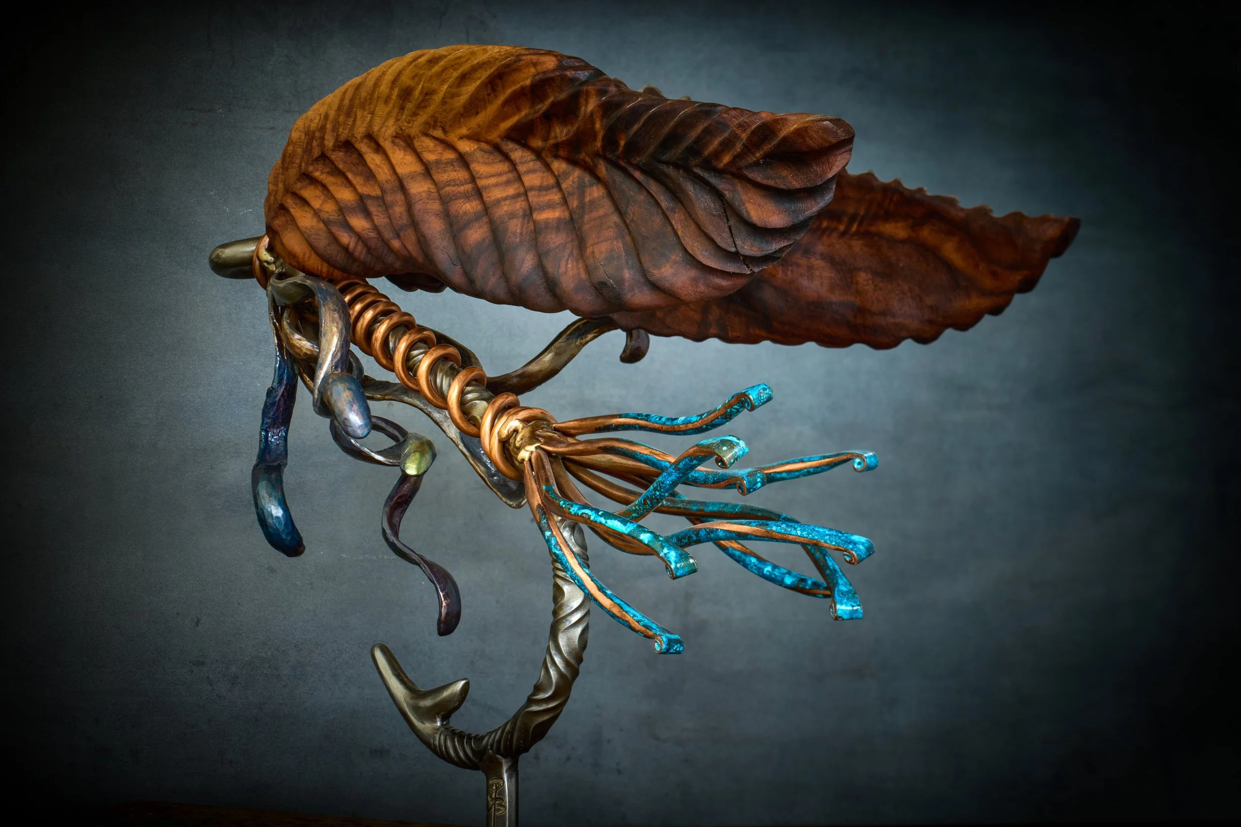 Lolo's Fly with the nicely wrapped copper body, blue patina tail, twisted steel hook, and hand carved walnut wing. 