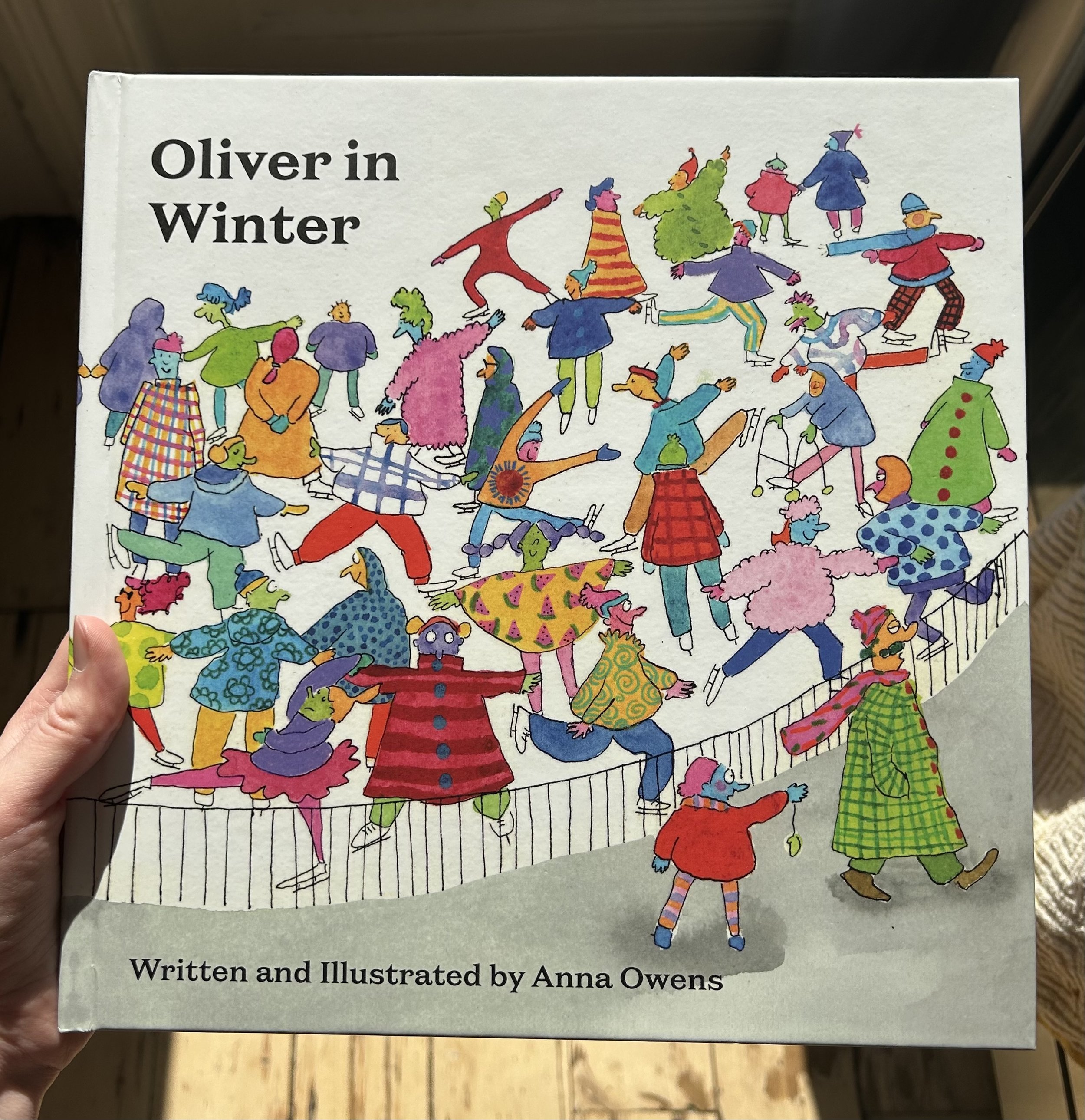 A colorful illustration of children ice skating; some are holding hands, others are skating independently, wearing winter clothes and accessories.