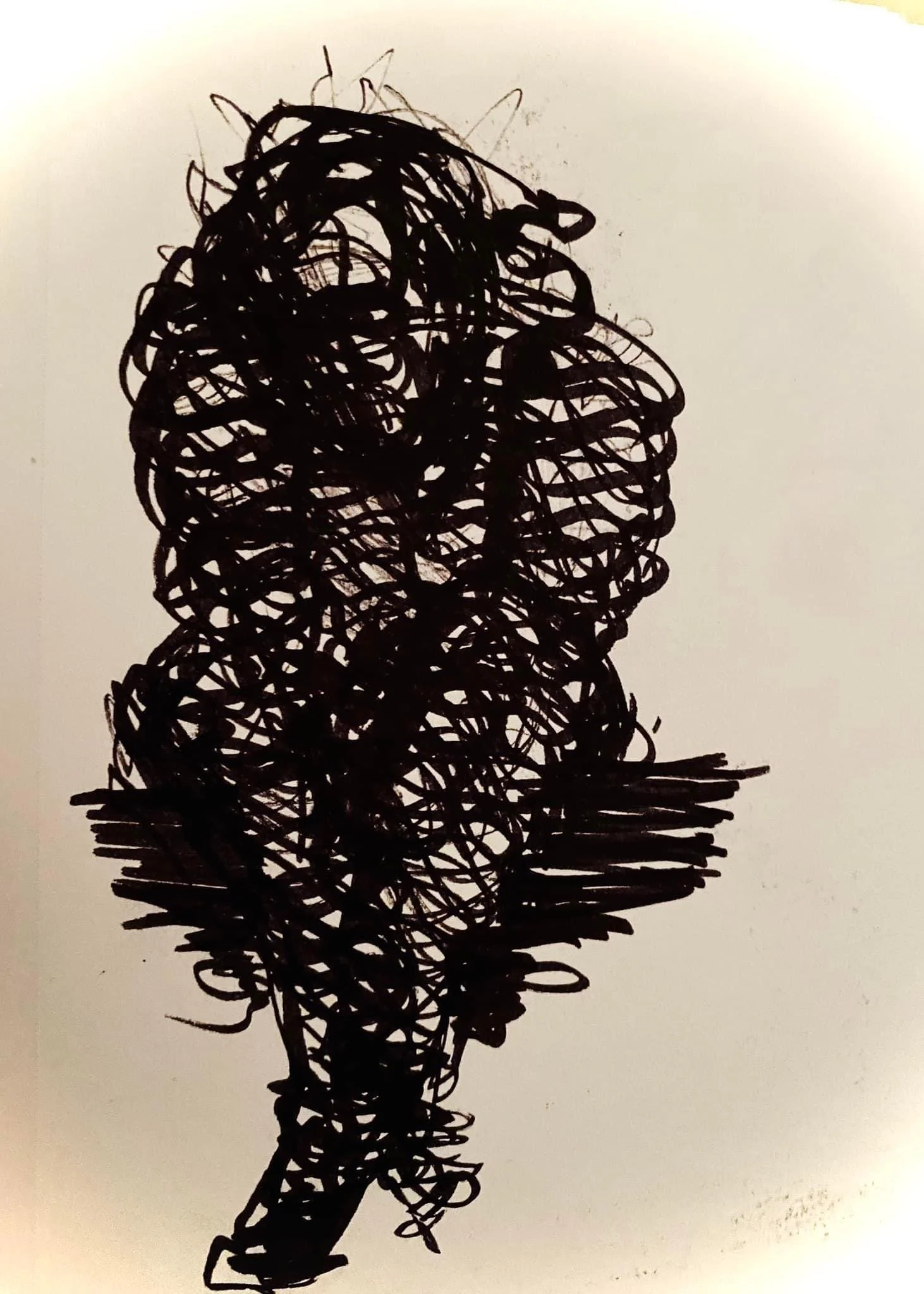 A black, abstract, scribbled drawing of a human head and upper body on a white background.