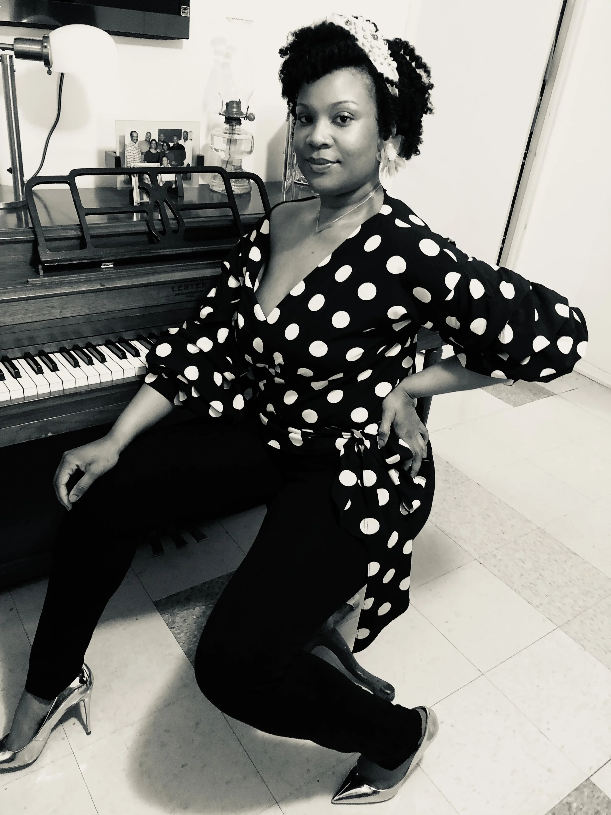 woman wearing polka dot blouse sitting at piano