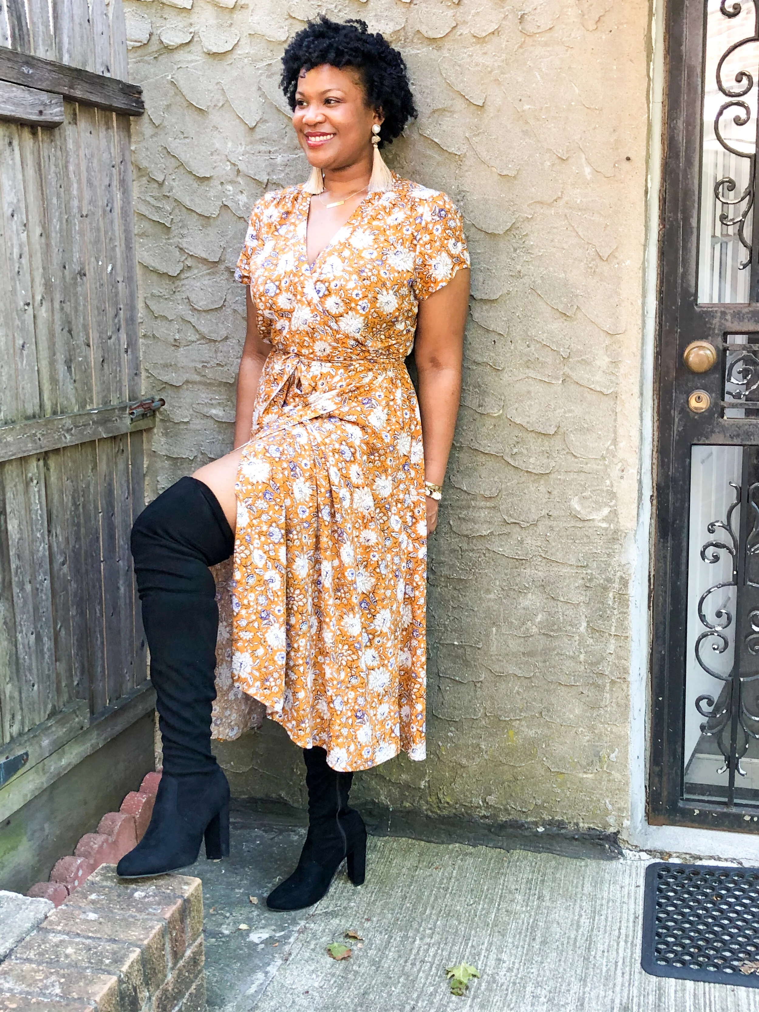 woman poses in yellow wrap dress and thigh high boots