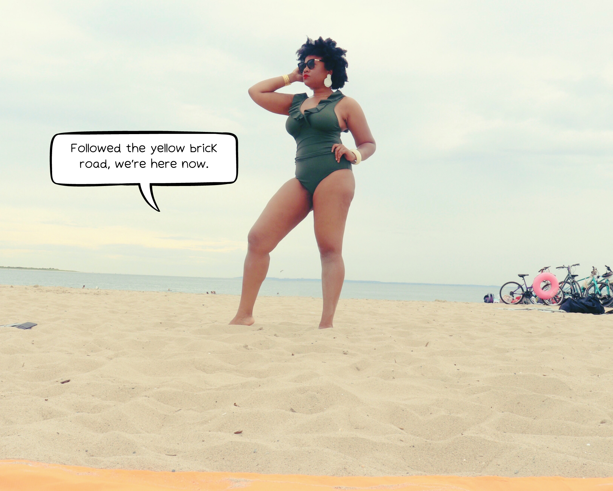 woman poses on beach in green swimsuit, comic strip bubble in the picture