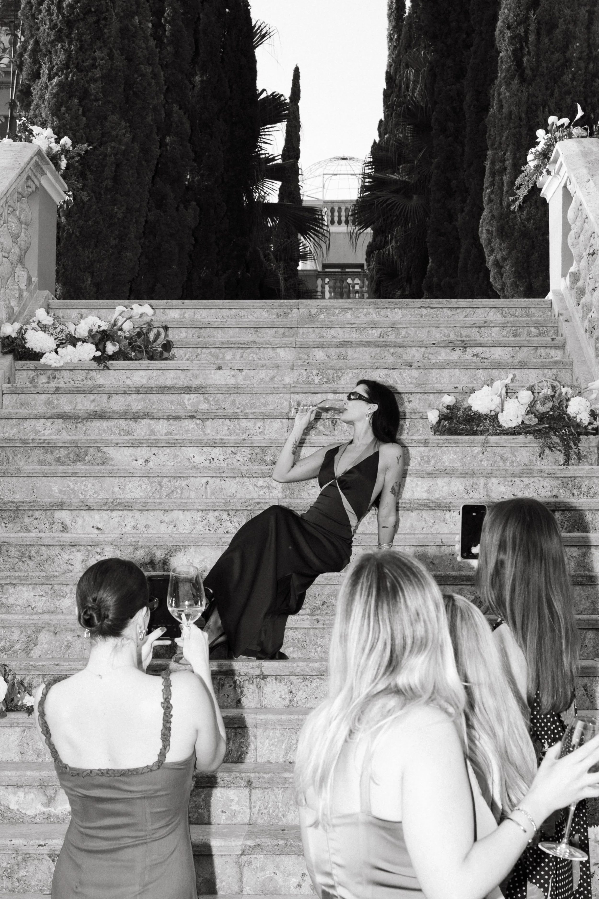Reception atmosphere Marbella destination wedding Spain, influencer having a glass of wine while others filming