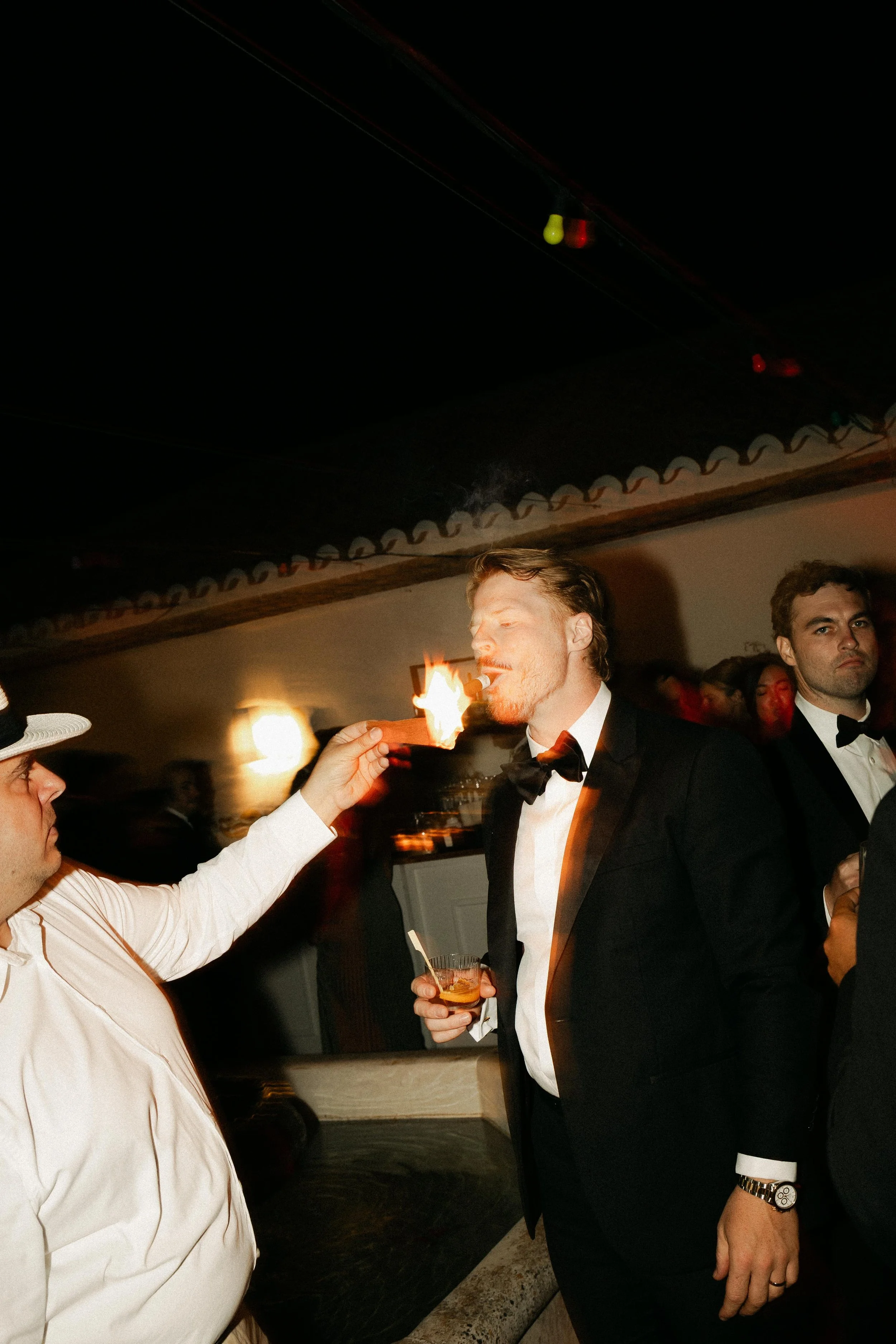 Spain destination wedding photographer capturing cigar rolling entertainment at the wedding