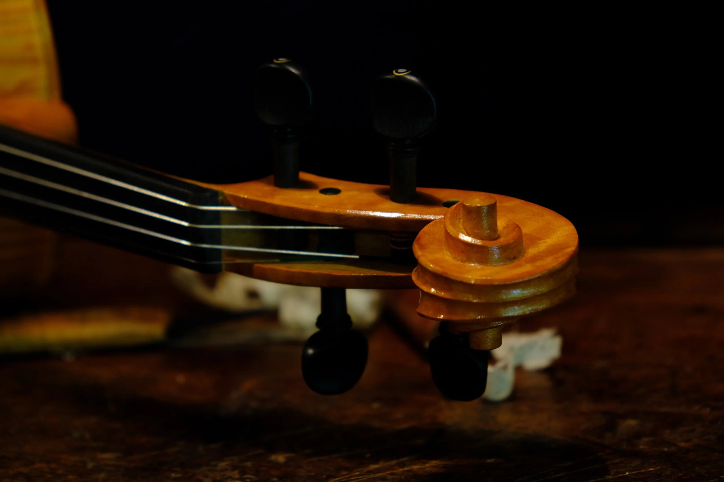 Close-up of the headstock of an acoustic guitar showing tuning pegs and part of the fretboard.