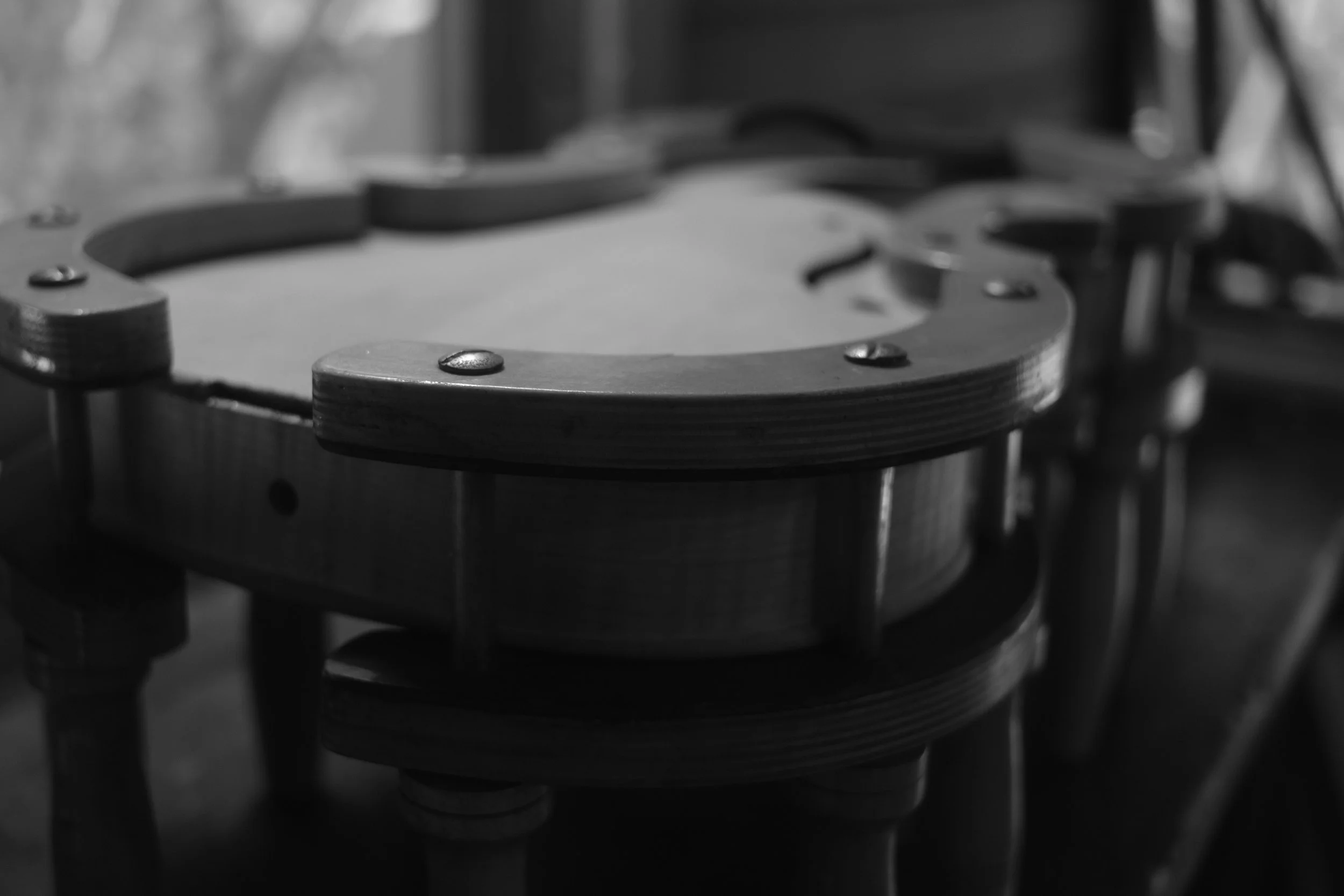 Black and white photo of a mechanical or industrial component, possibly a part of a machine or apparatus, with metal and wooden elements and screws.