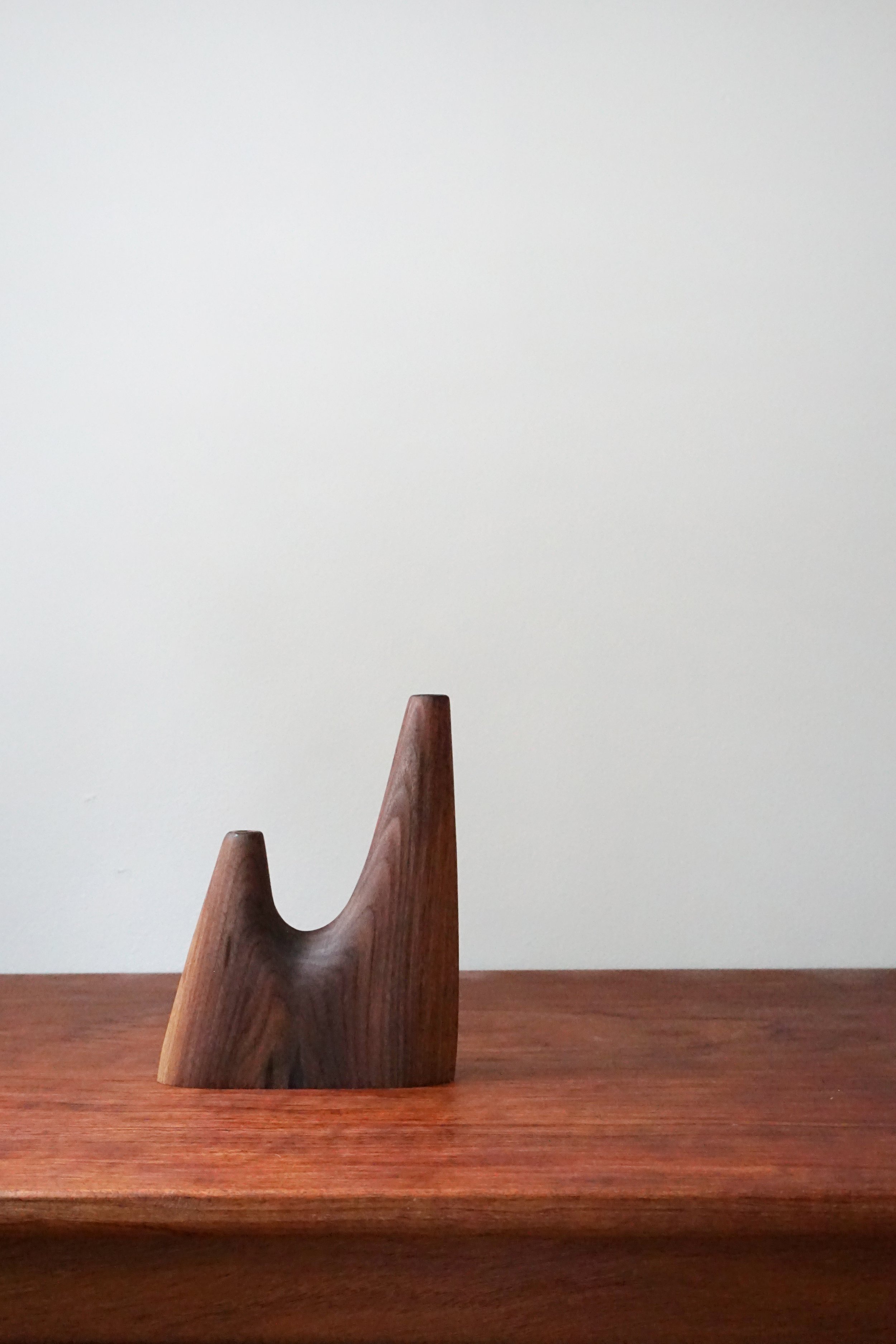 Wooden sculpture on a wooden table against a plain white wall.