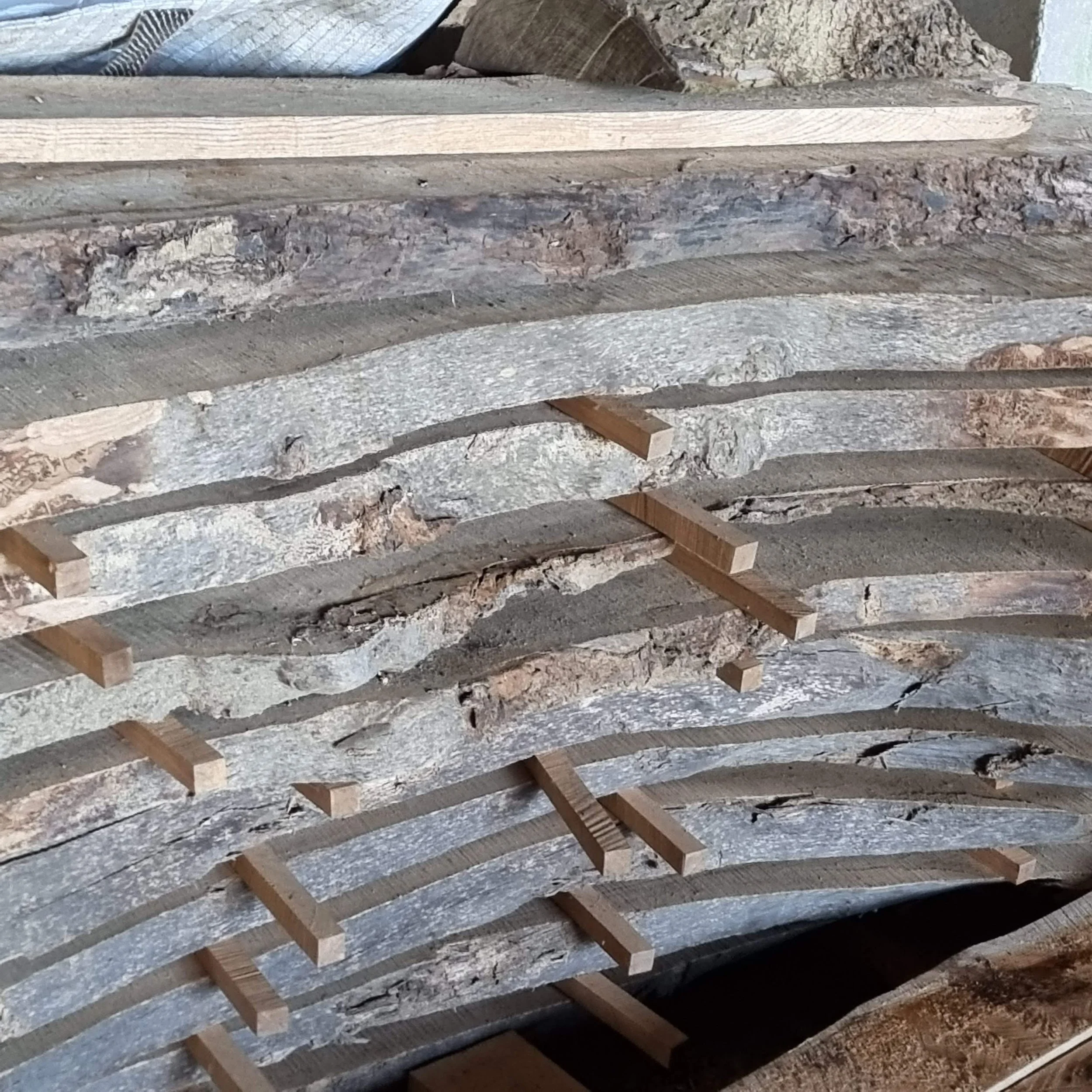 Stack of curved wooden beams with small support blocks in between